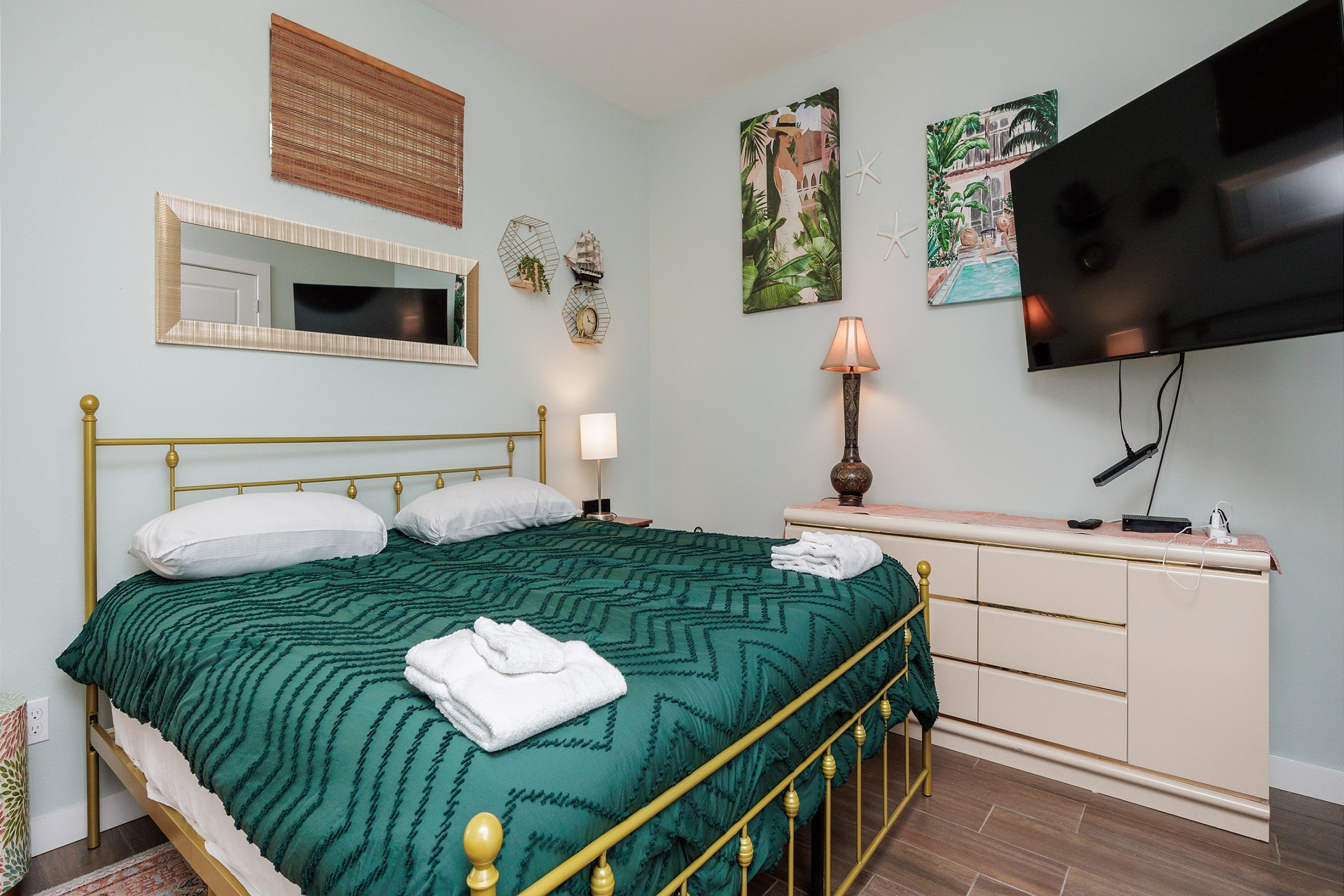 Master bedroom on the first floor with king size bed, private bathroom, access to private patio, and 55-inch flat screen TV