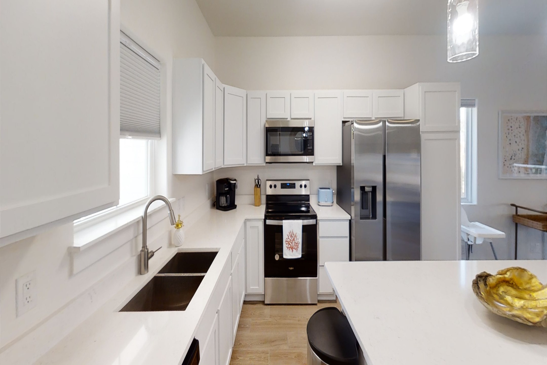 Fully equipped kitchen with coffee maker, toaster, cookware, dinnerware, and other kitchen essentials provided