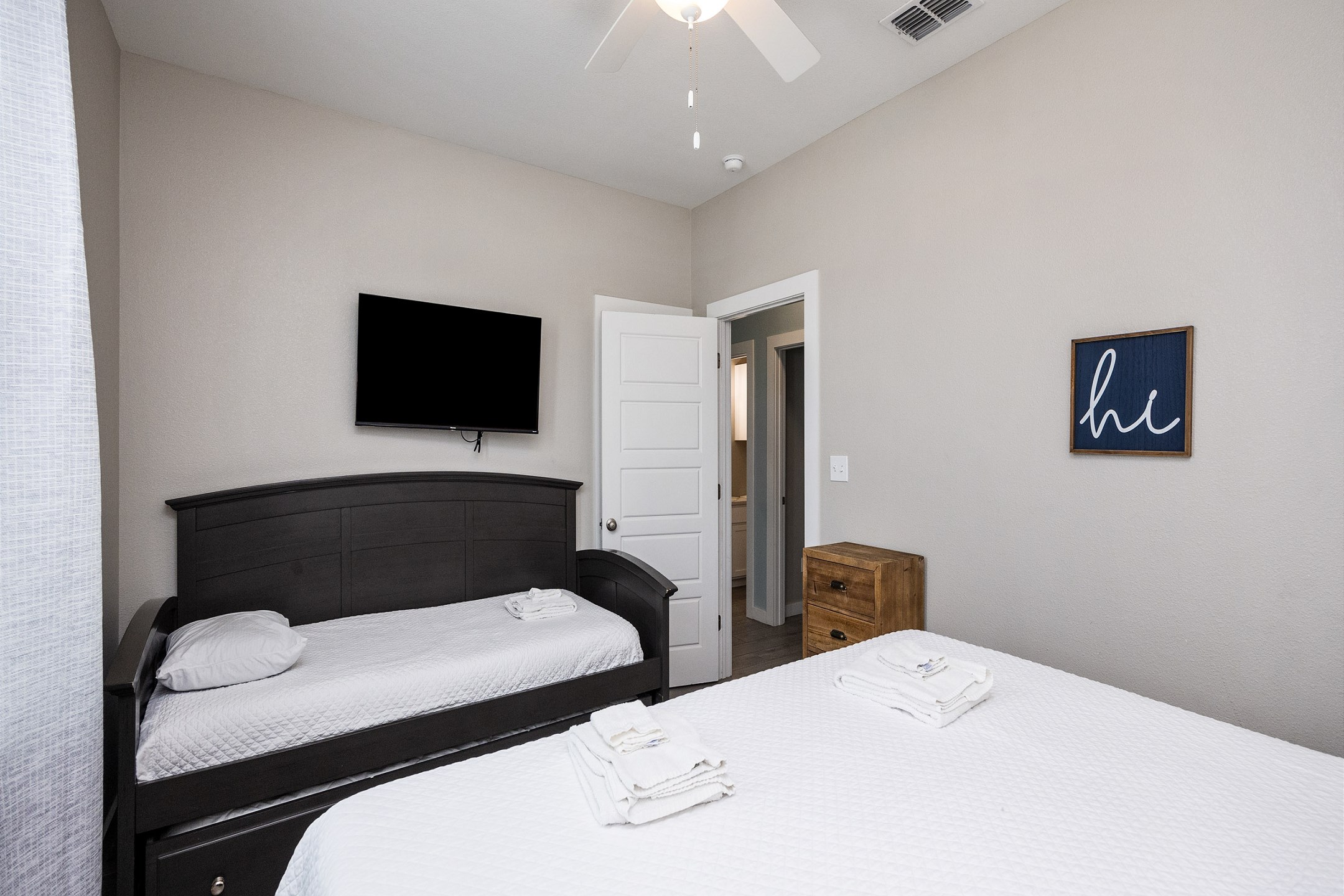 Second bedroom on the second floor with a king size bed, twin daybed, and twin trundle, along with flat screen TV