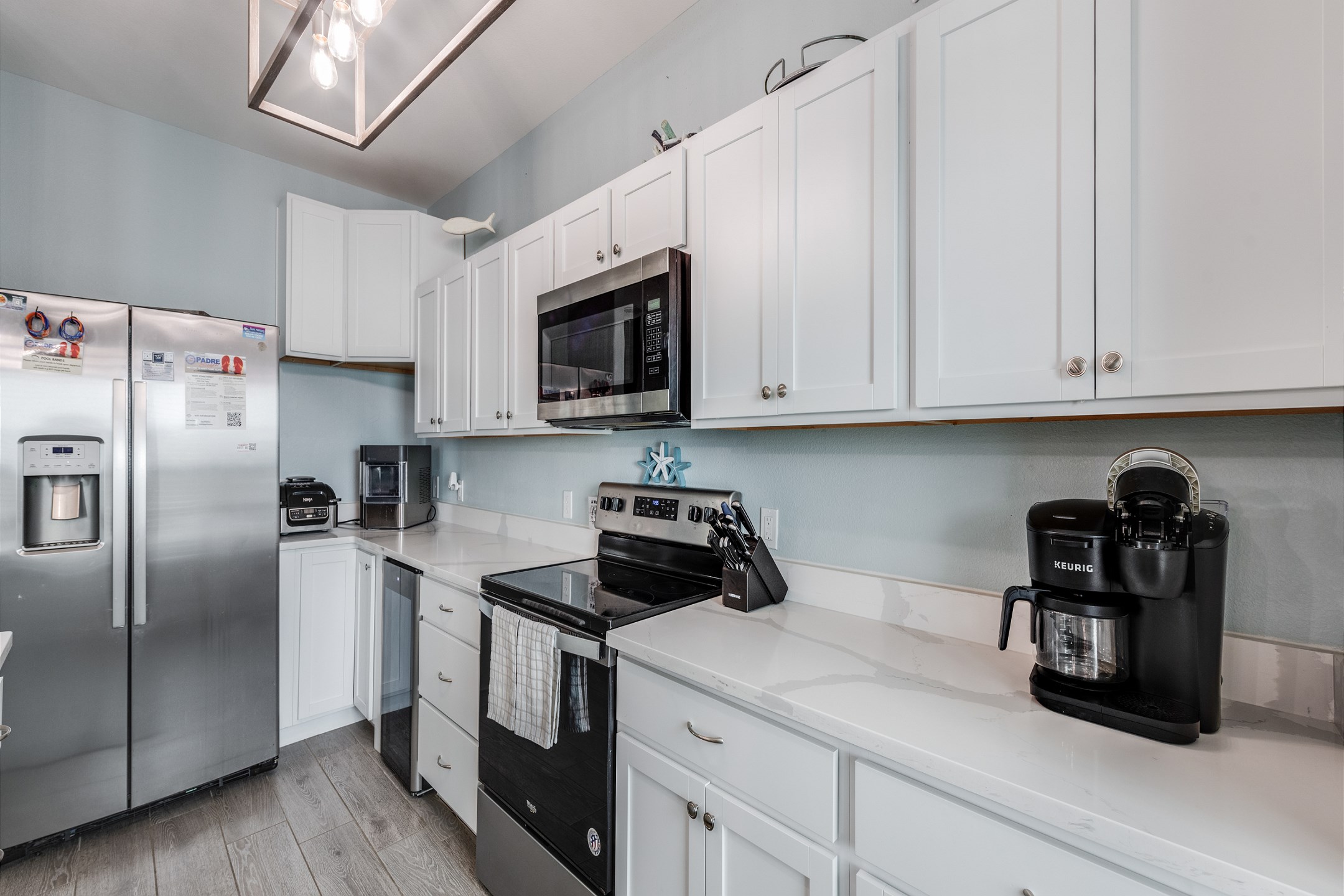 Fully equipped kitchen with coffee maker, toaster, cookware, dinnerware, and other kitchen essentials provided