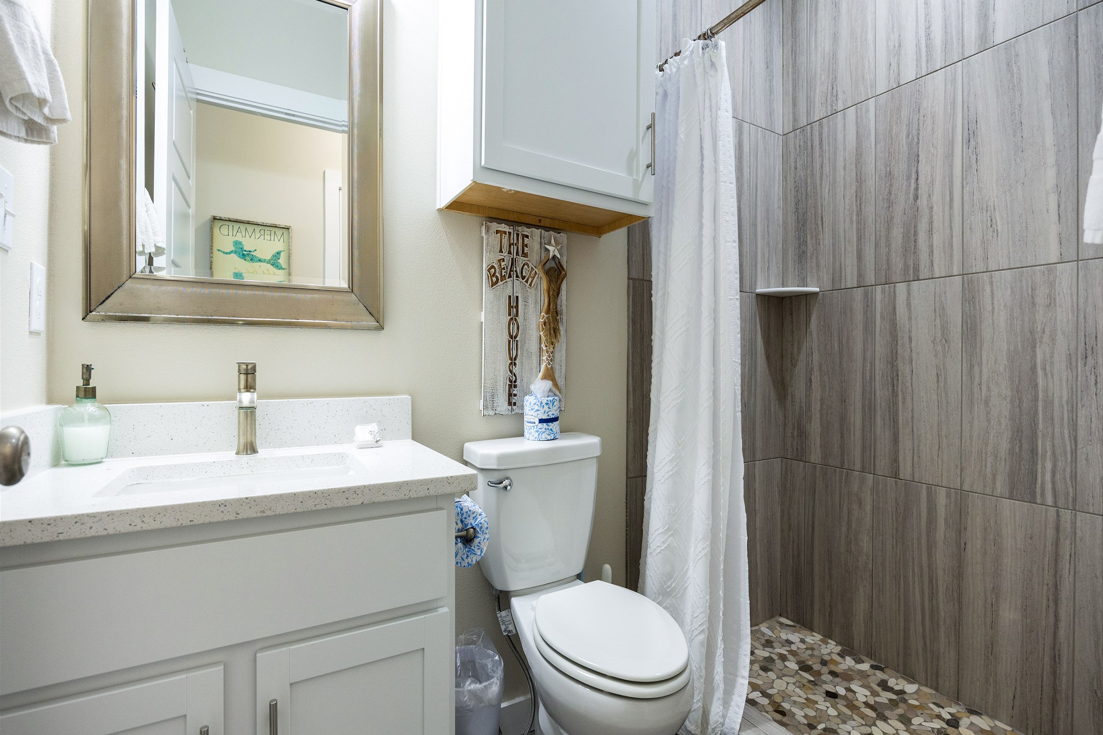 The upstairs master bathroom offers a sleek sink and a spacious walk-in shower—perfect for refreshing after a sun-soaked day.