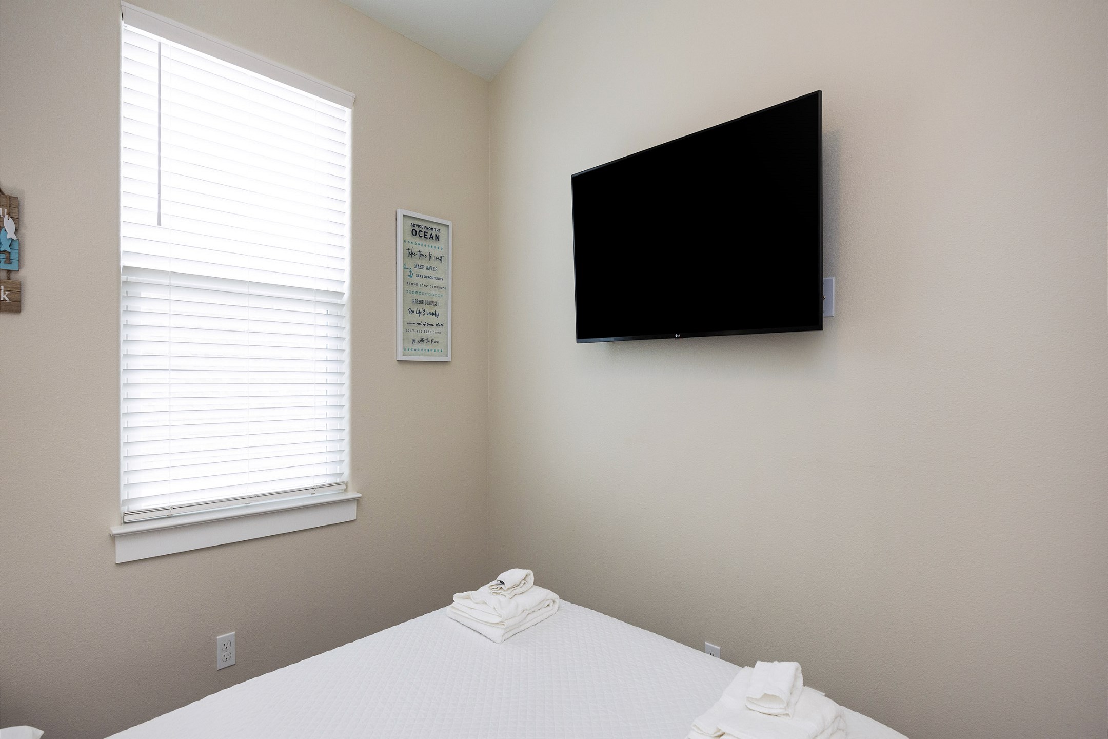Second-floor bedroom with a cozy queen bed and flat screen TV—perfect for a restful night after a day in the sun.