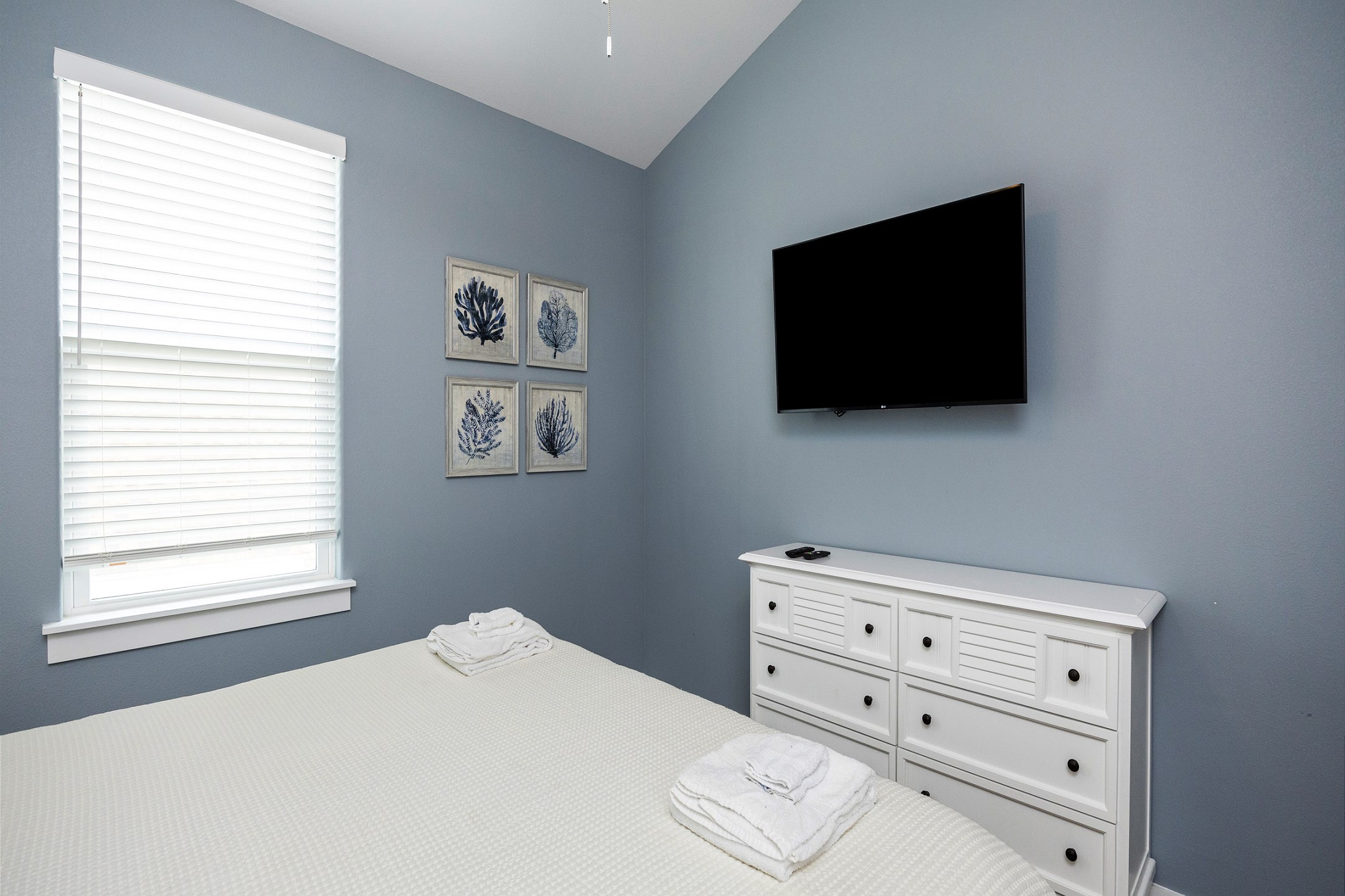 Master bedroom on the second floor with a king size bed, private bathroom, and flat screen TV