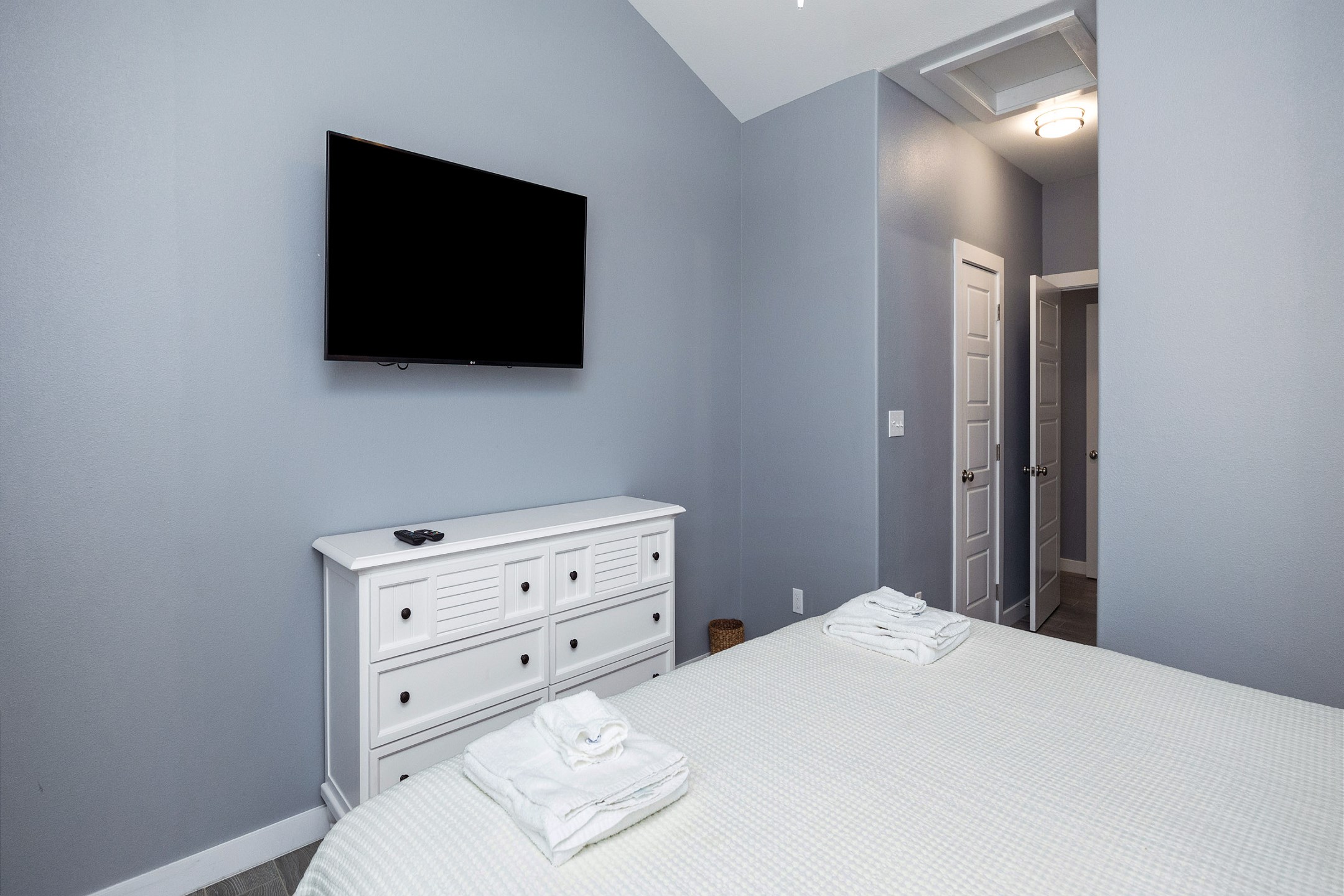 Master bedroom on the second floor with a king size bed, private bathroom, and flat screen TV