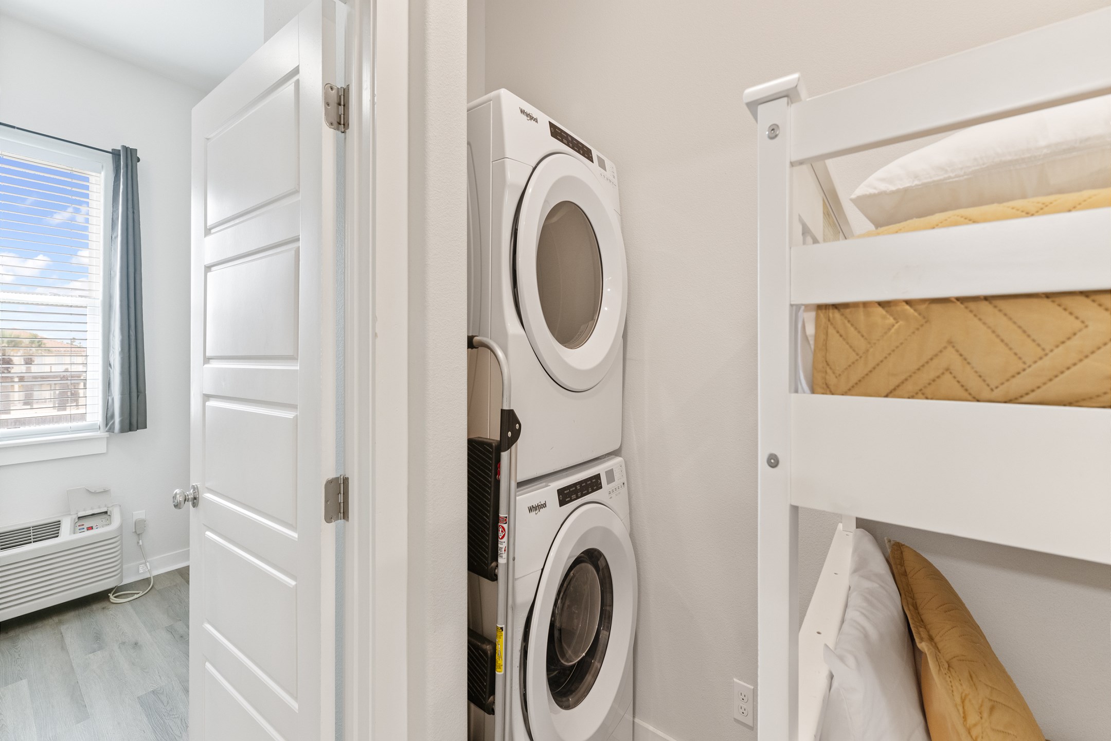 Stackable washer and dryer in hallway next to master bedroom