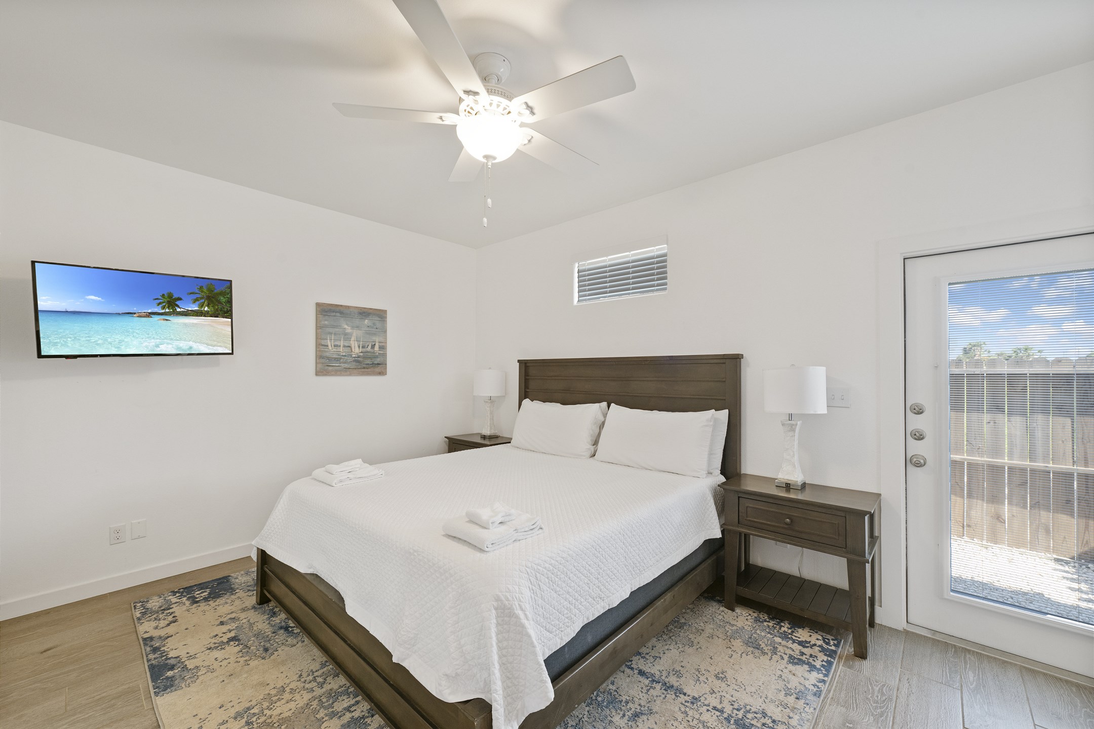 Master bedroom on the first floor with king size bed, private bathroom, access to private patio, and flat screen TV