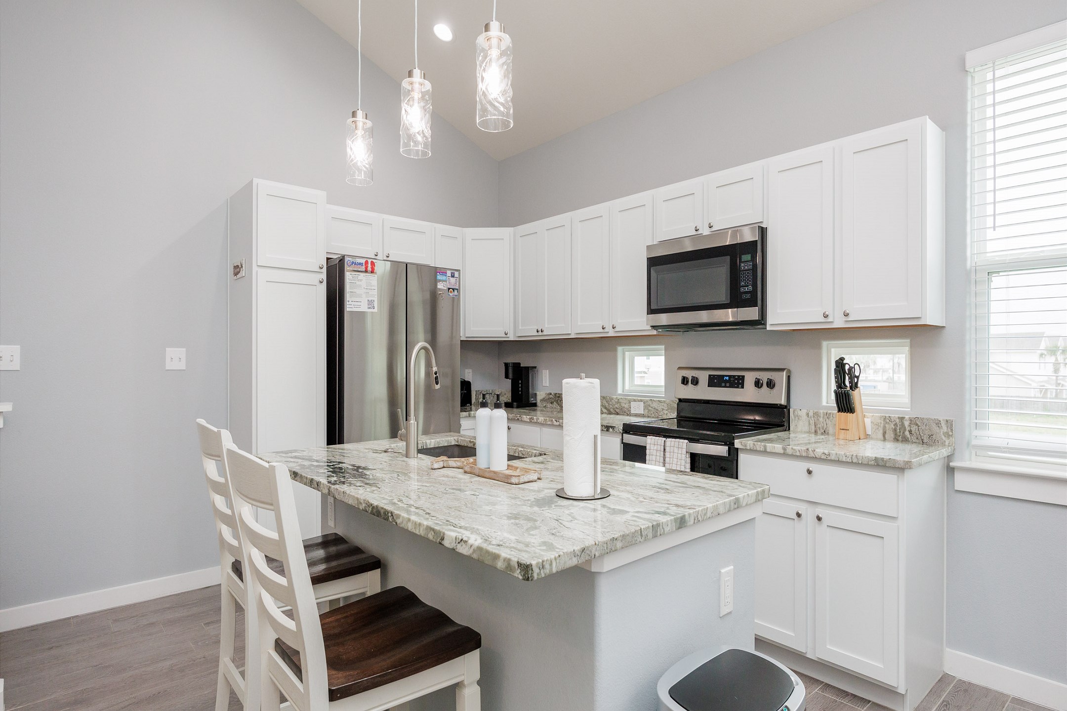 Fully equipped kitchen featuring gorgeous countertops, ample storage, and a breakfast bar with seating for two