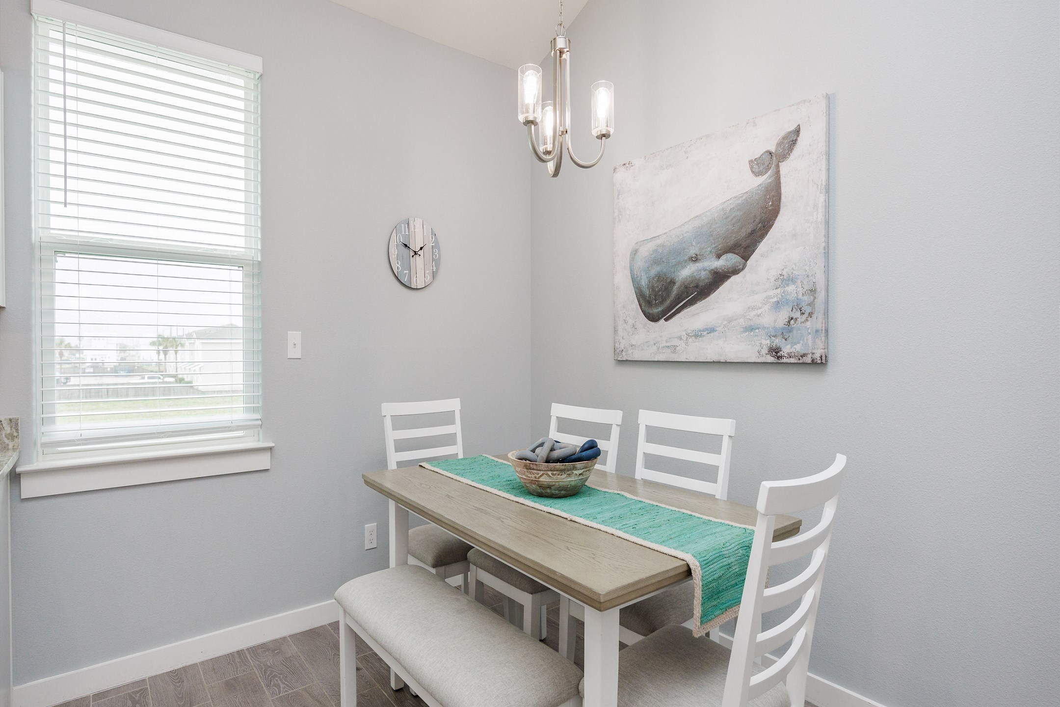 Quaint dining space with Whalecome-themed artwork