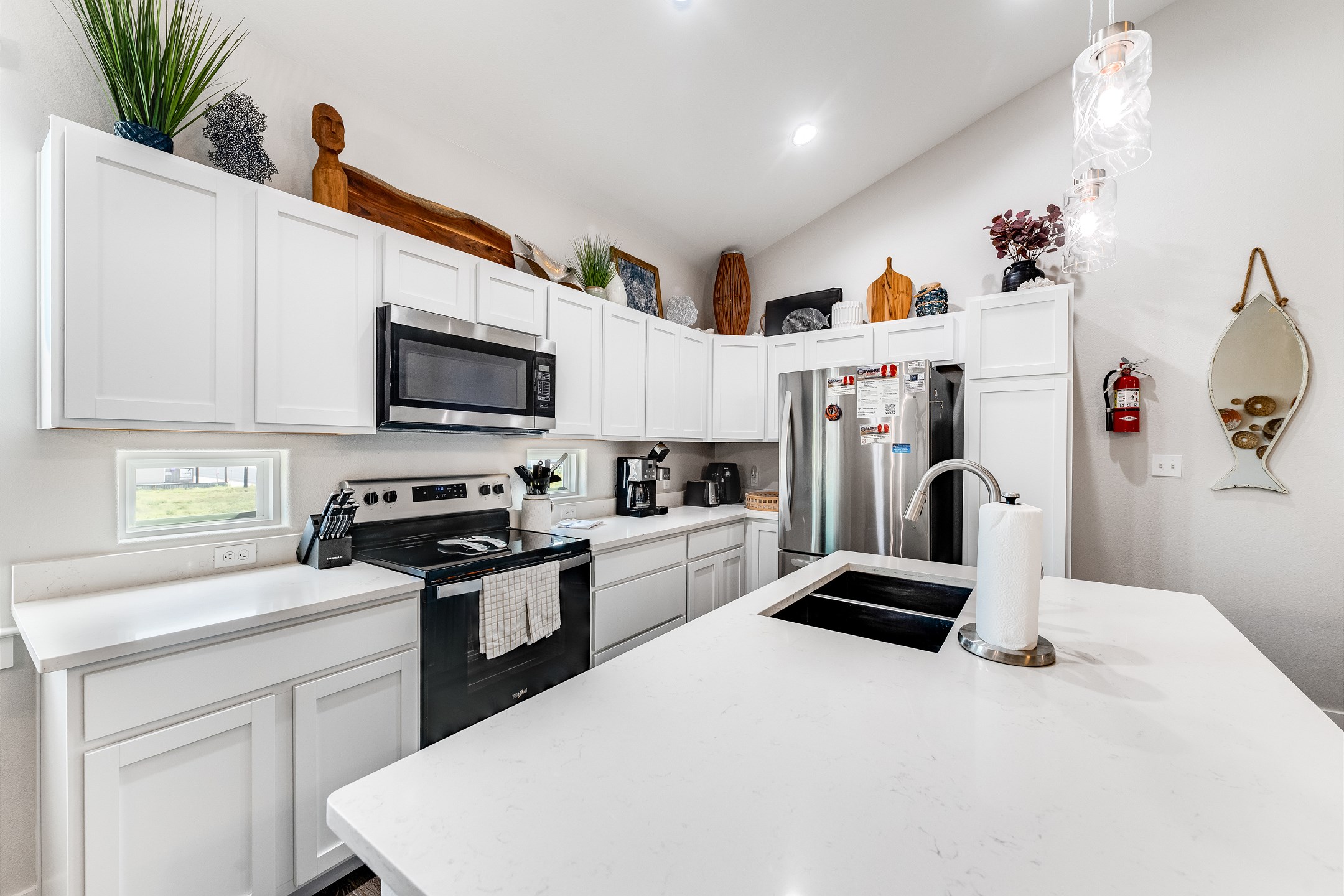Fully stocked kitchen with barstools and coffee maker 