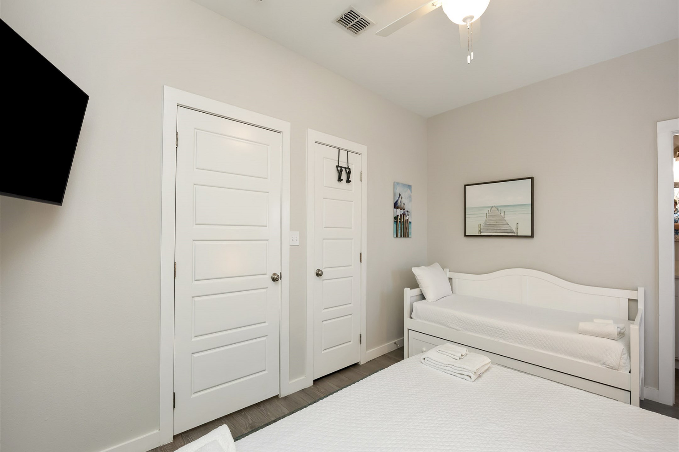 Master bedroom on the first floor with king size bed, twin daybed with trundle, back patio access, private bathroom and flat screen TV