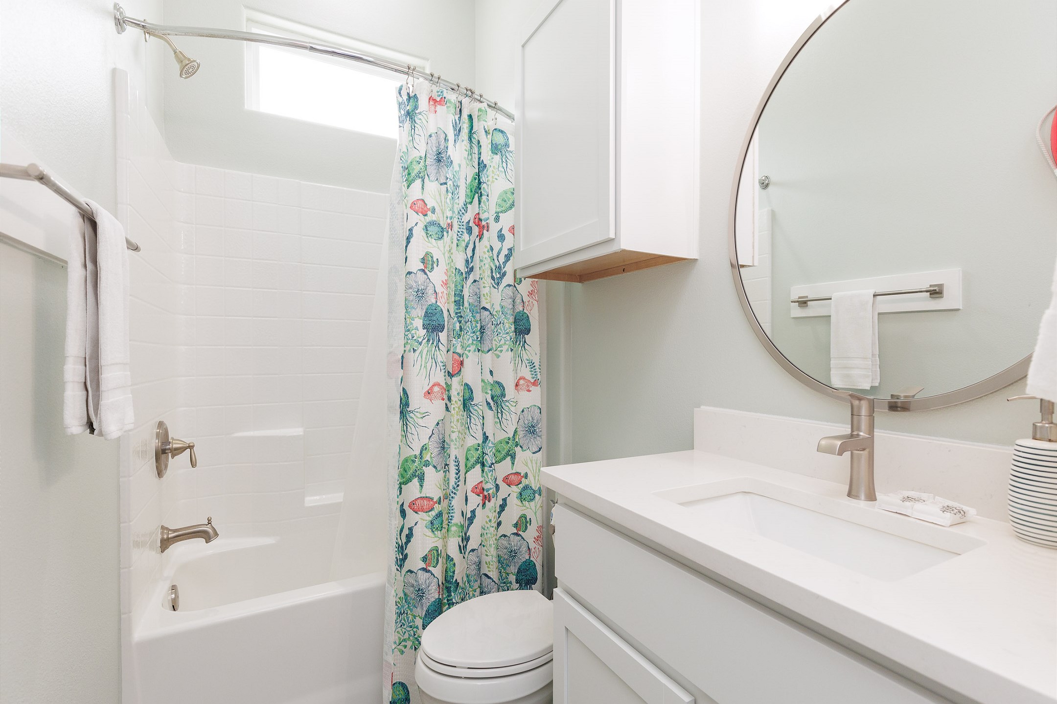 Guest hallway bathroom featuring toilet, sink, and tub/shower combo 
