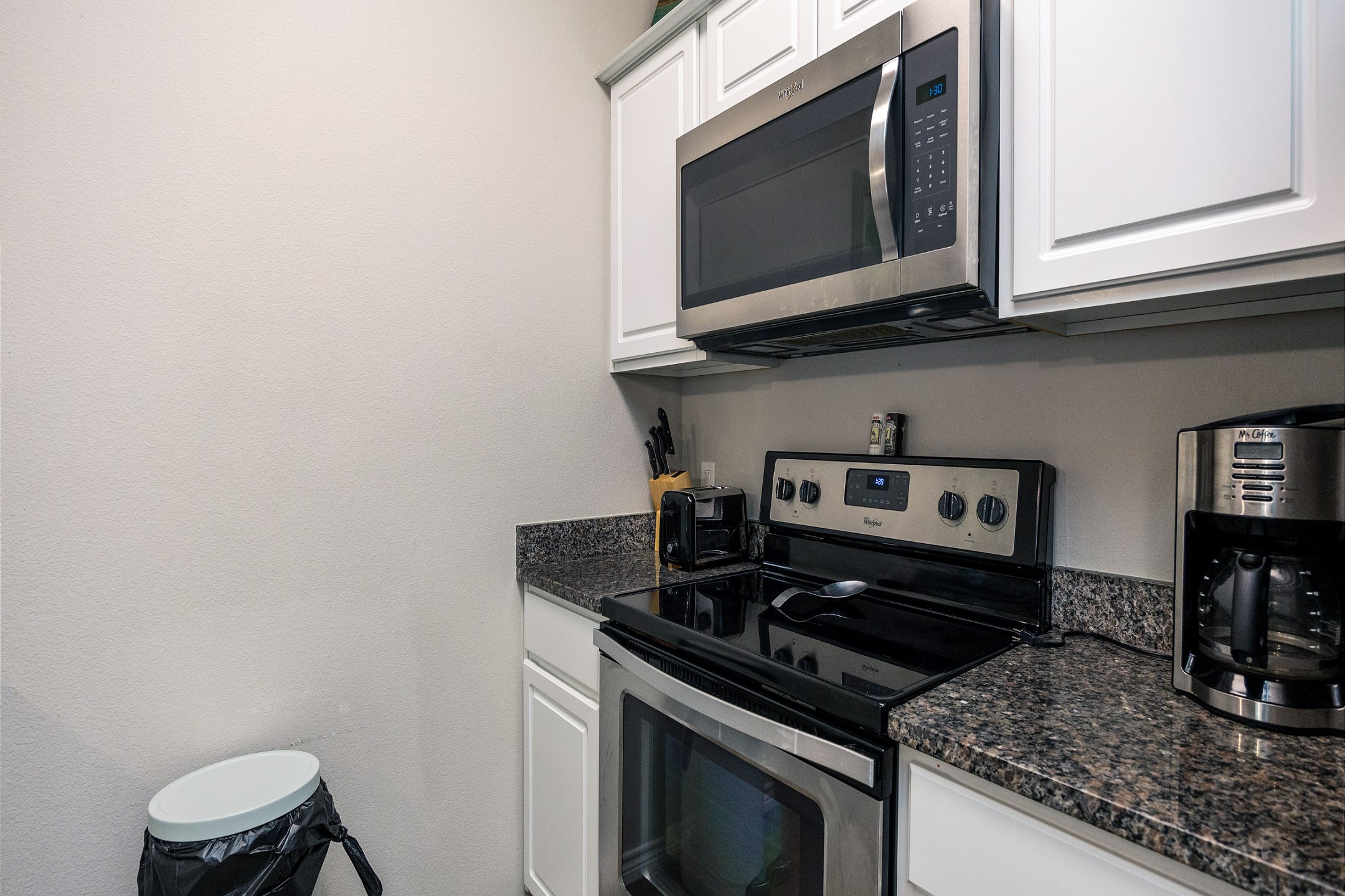 Fully equipped kitchen with coffee maker, toaster, cookware, dinnerware, and other kitchen essentials provided