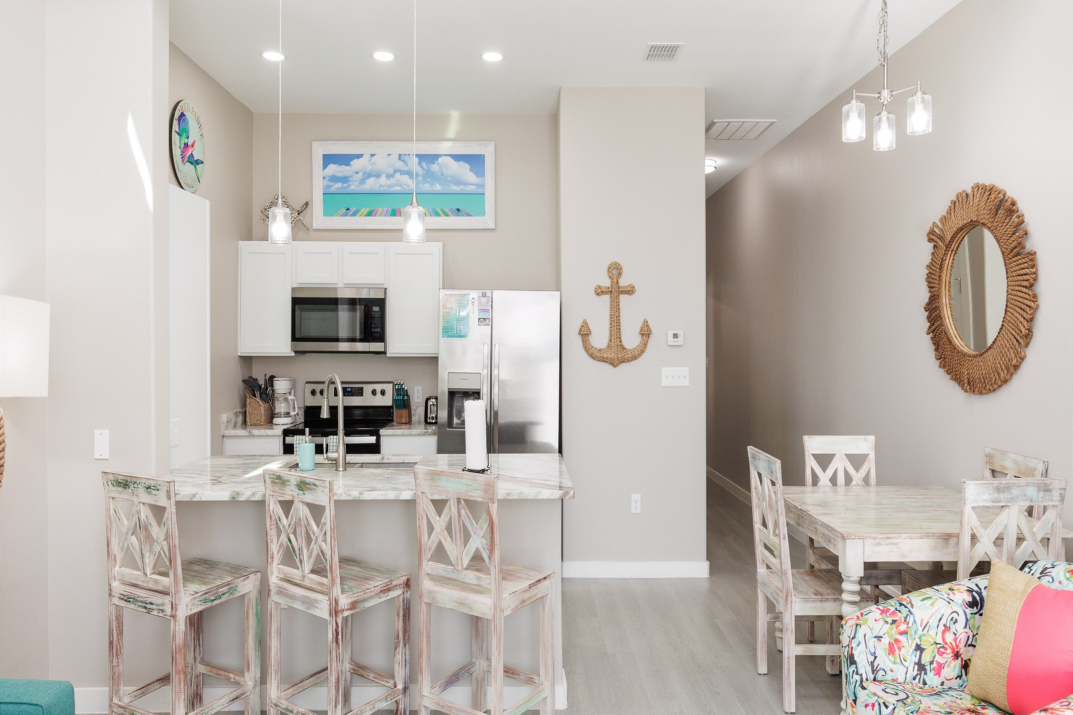 Kitchen and dining area with a breakfast bar for three, coastal decor, and modern features