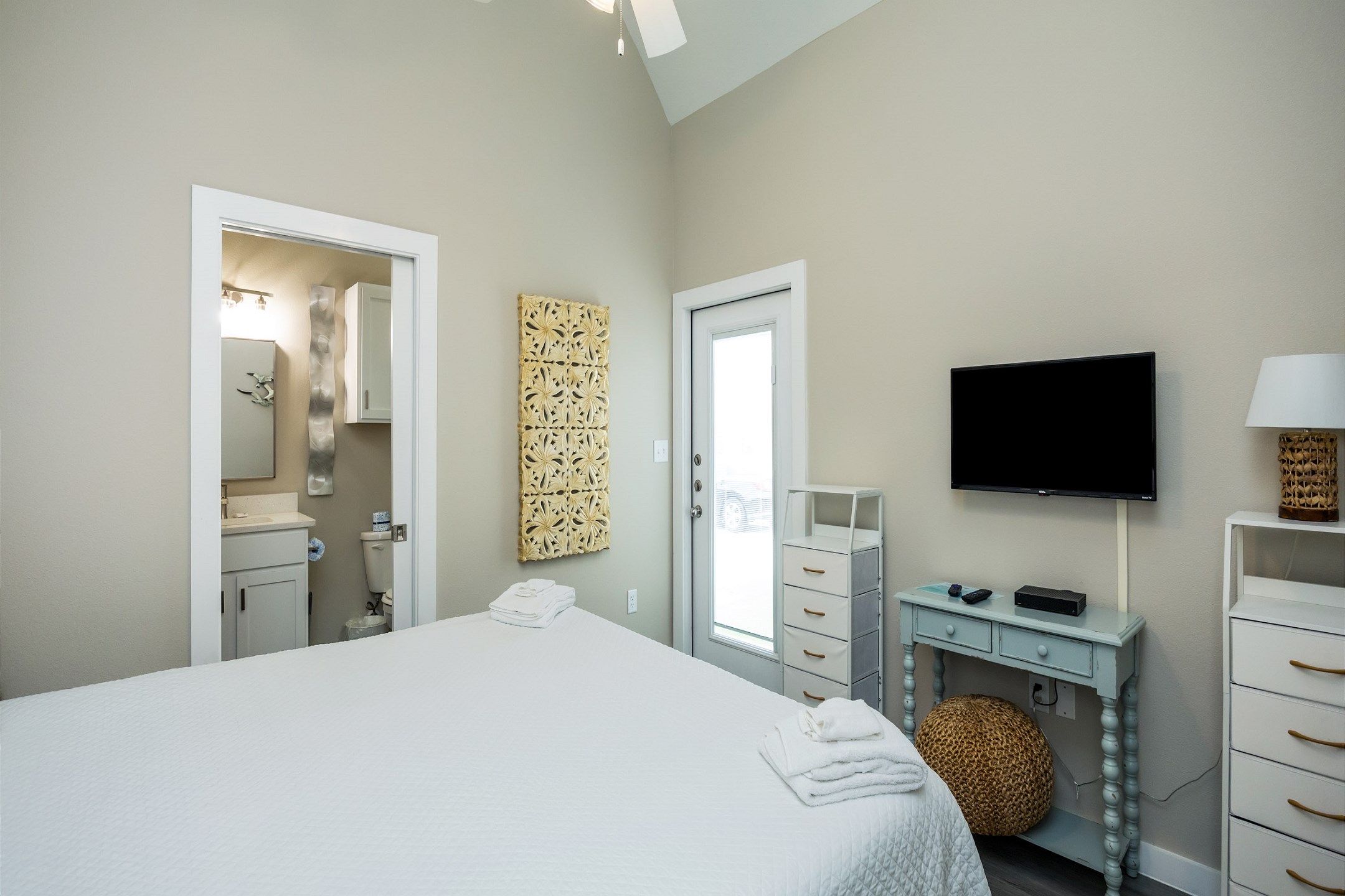 Master bedroom with king size bed, private bathroom, along with a flat screen TV and exterior access