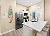 Fully equipped kitchen with barstools and coffee maker 