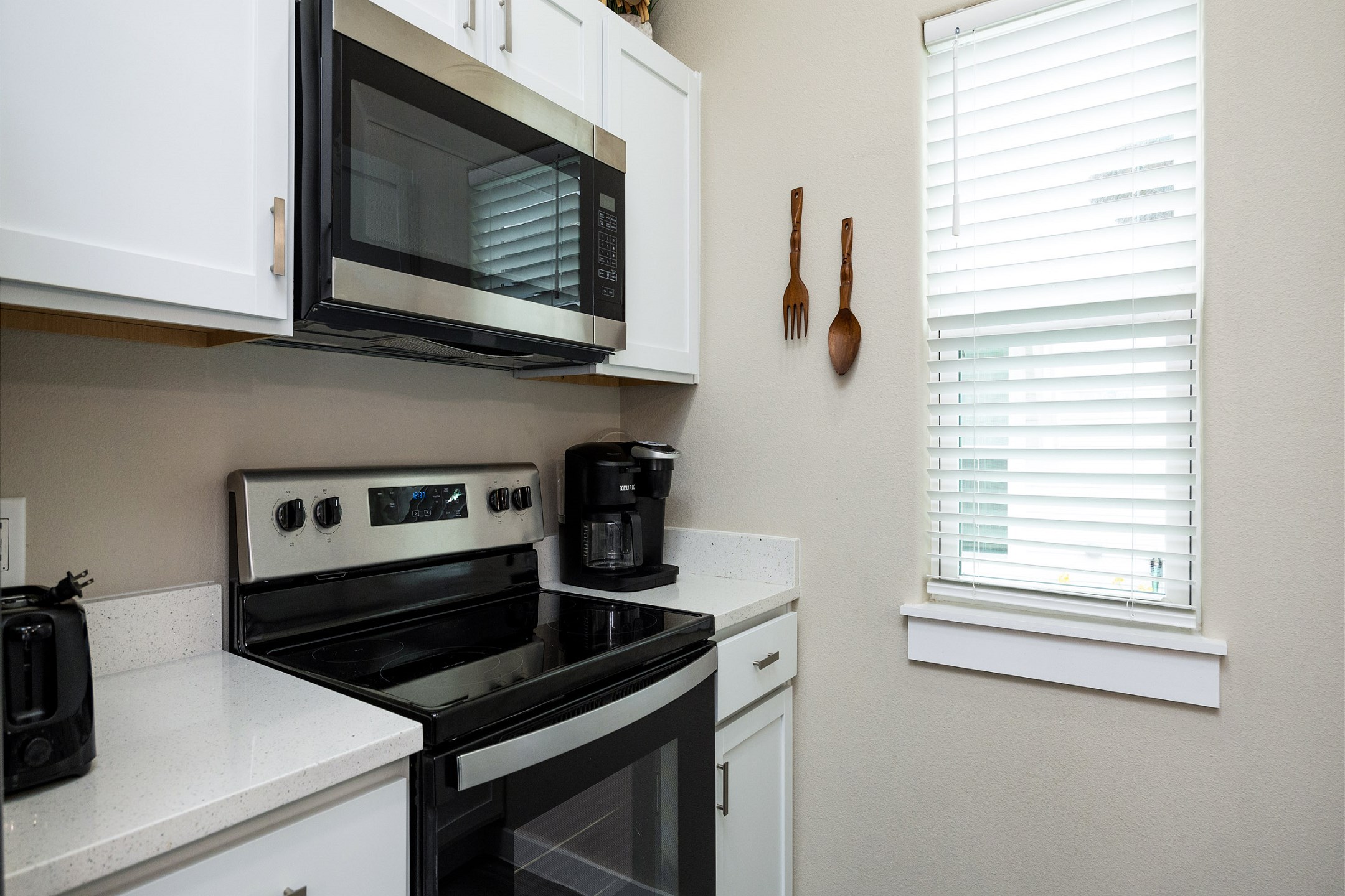 Fully equipped kitchen with coffee maker, toaster, cookware, dinnerware, and other kitchen essentials provided