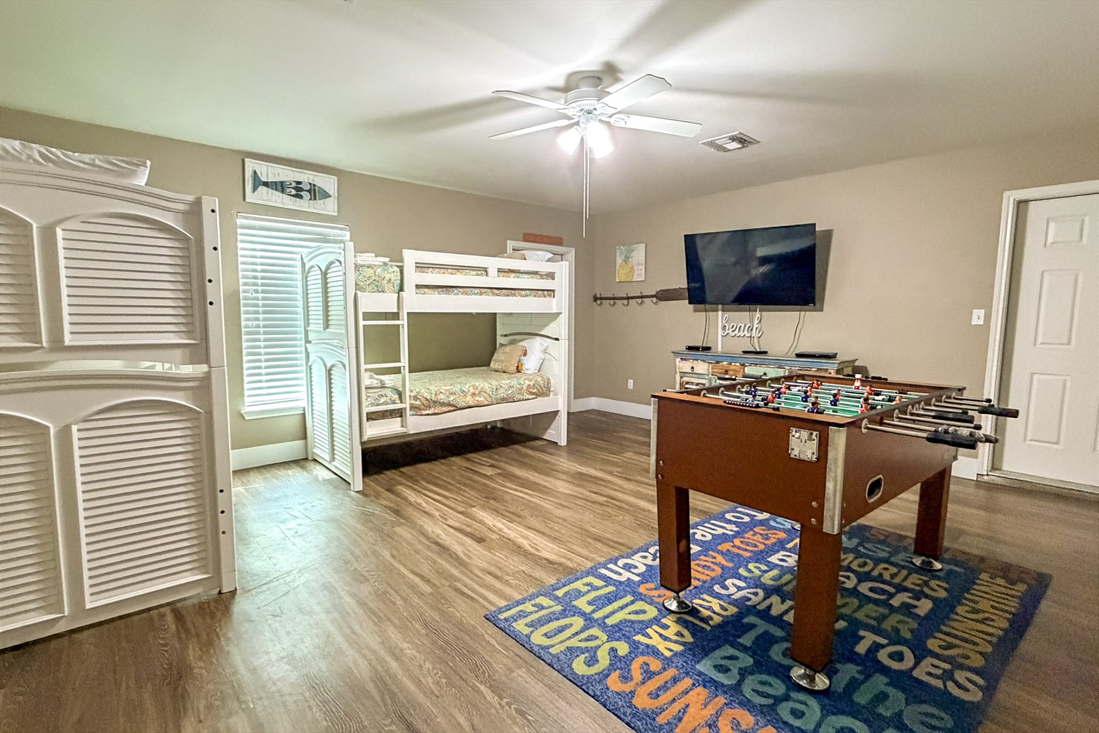 First floor media room with four twin size beds, flat screen TV and foosball table to enjoy