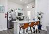 Dining area with modern appliances and three bar stools for entertaining 