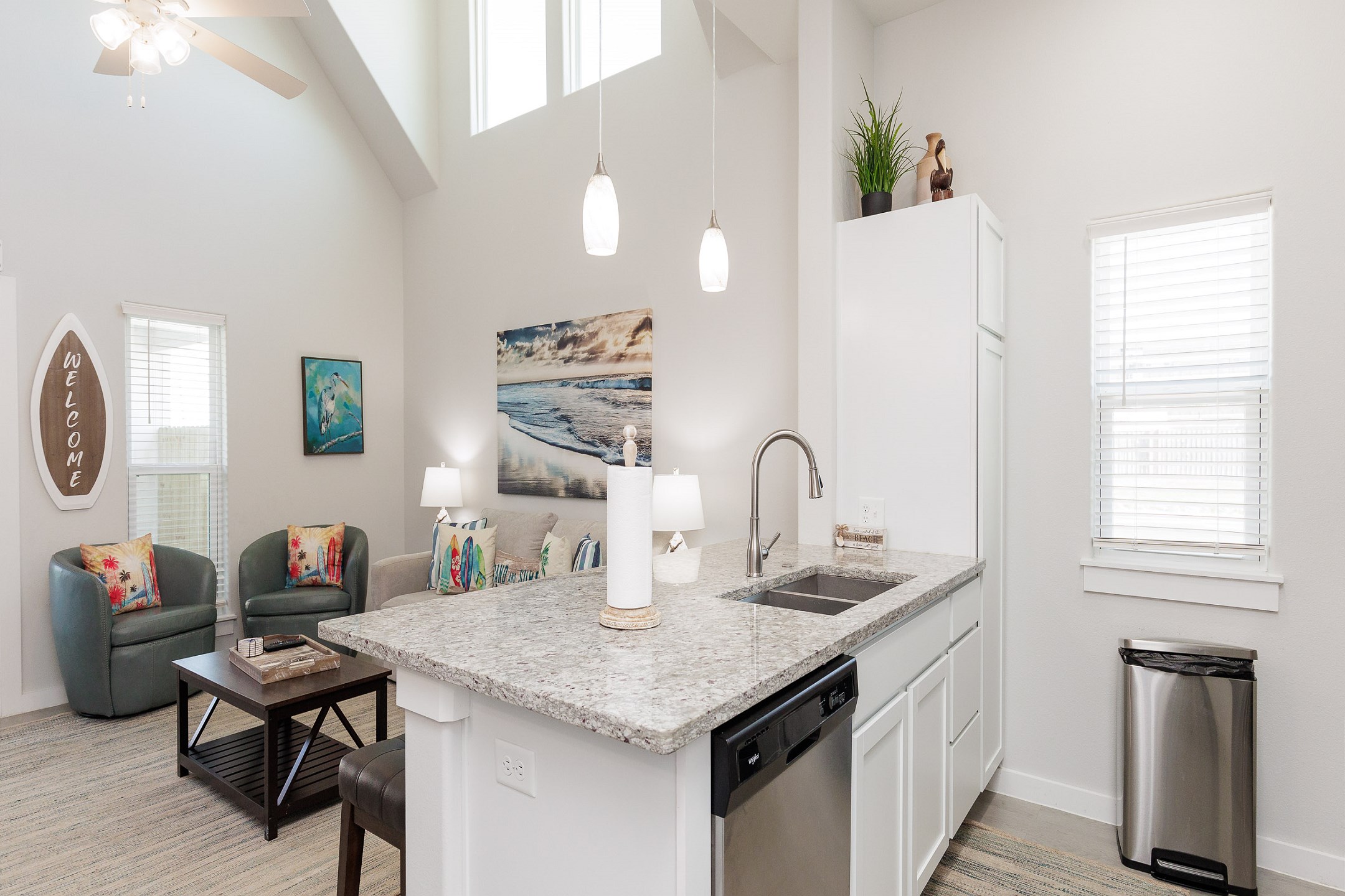 Open concept living and kitchen area with high ceilings, coastal decor and beautiful features throughout 