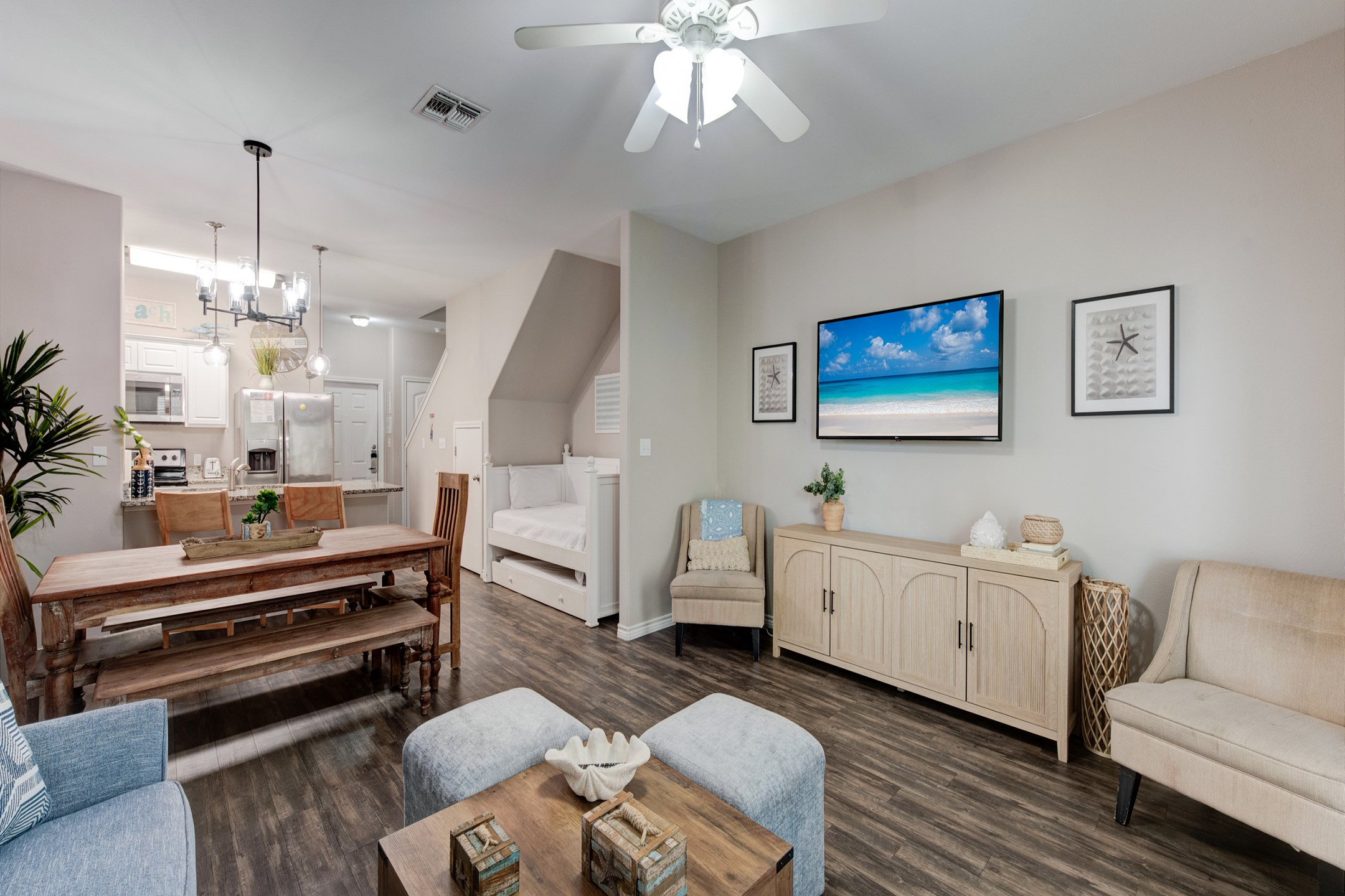 Open-concept living area featuring a flat-screen TV and a daybed with a trundle, located just across from the dining area