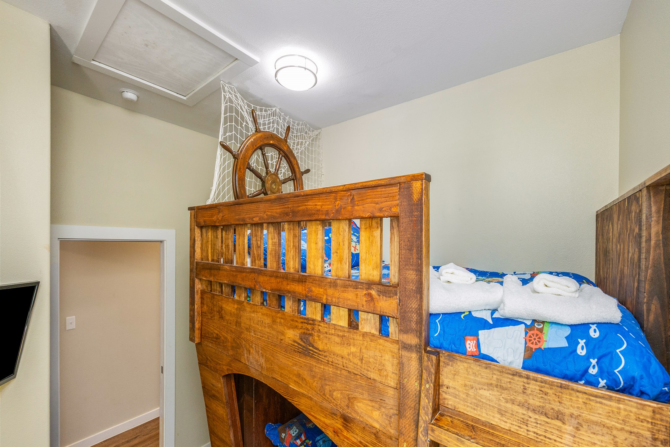 Second bedroom featuring a full-over-twin pirate ship bunk bed and a flat-screen TV for added comfort and entertainment