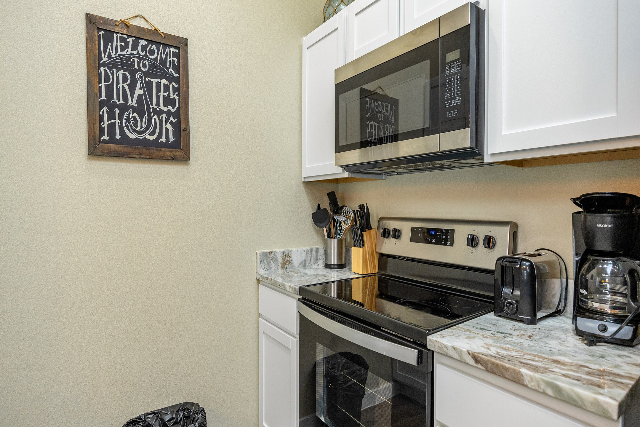 Fully equipped kitchen with coffee maker, toaster, cookware, dinnerware, and other kitchen essentials provided
