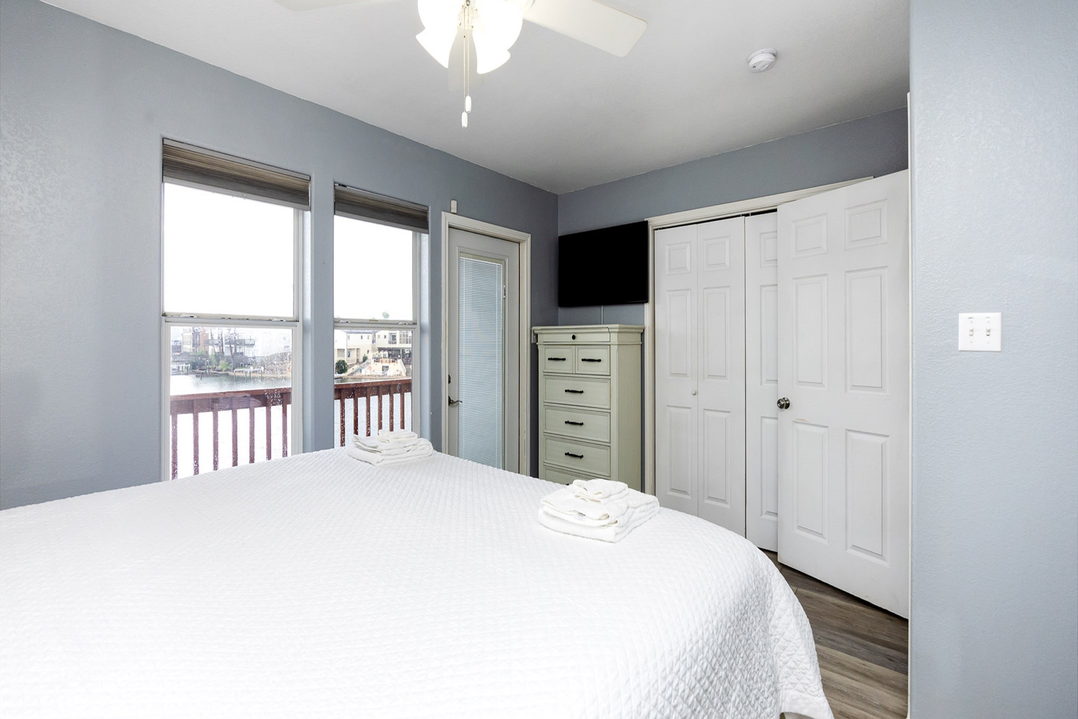 Master bedroom on the second floor with king size bed, flat screen TV, and private balcony access 