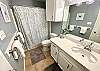 Master bathroom with single sink, toilet, and walk-in shower 