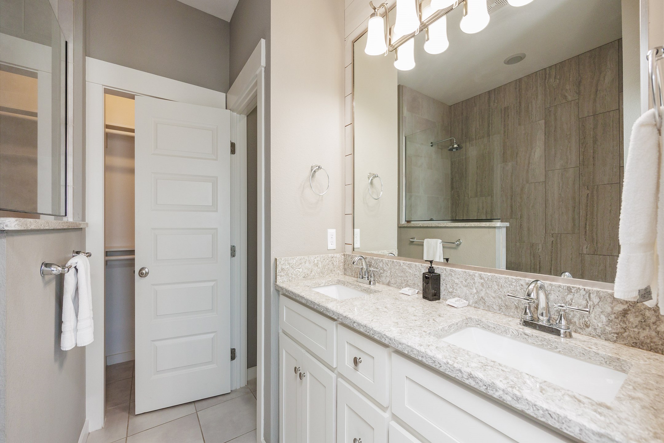 Master bathroom with double sinks, toilet, and walk-in shower 