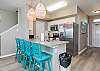 Fully equipped kitchen with stainless steel appliances and breakfast bar that seats four 