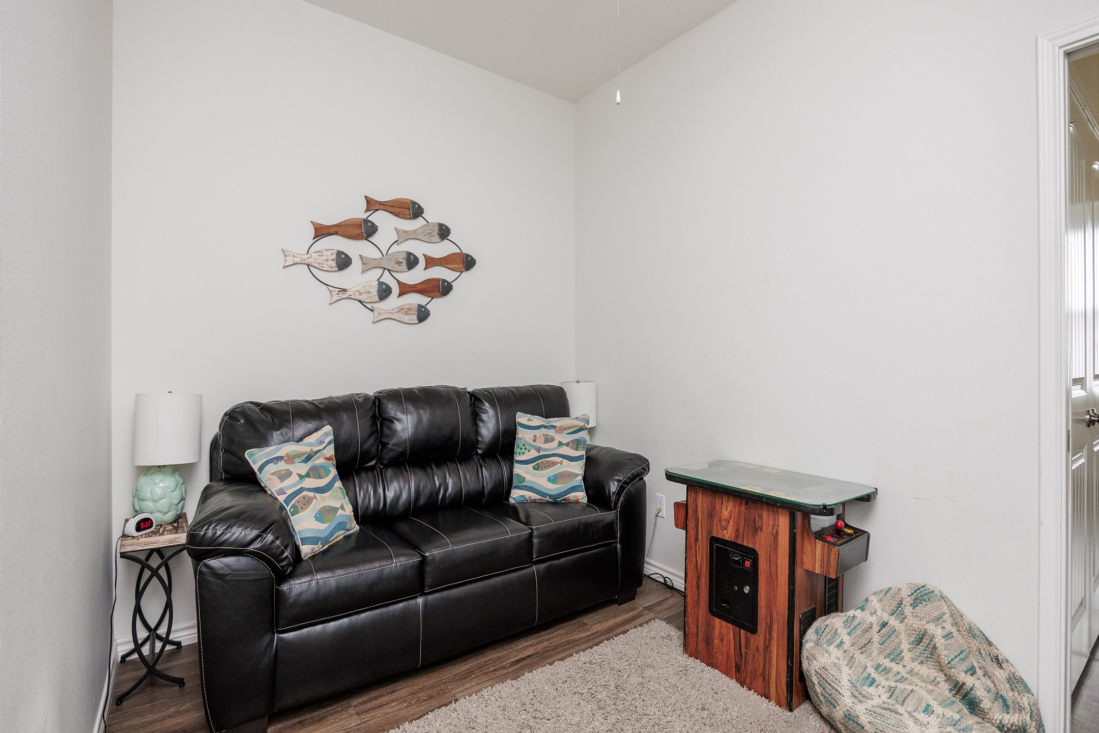 Media room on the second floor with comfortable seating and arcade game 