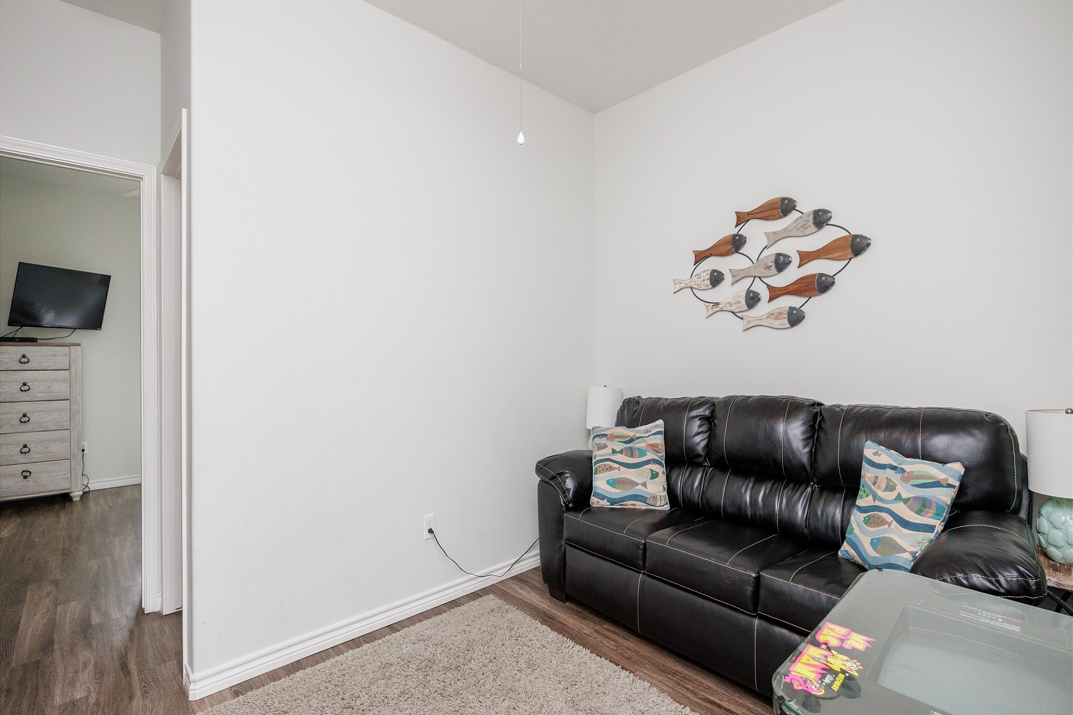 Media room on the second floor with comfortable seating and arcade game