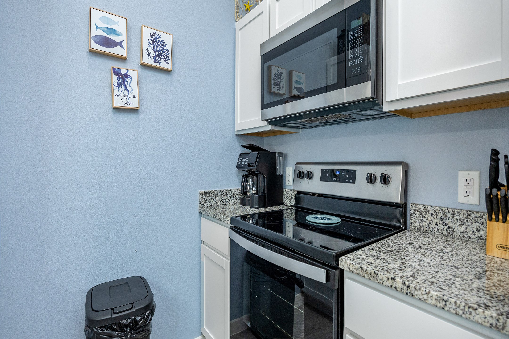 Fully equipped kitchen with coffee maker, toaster, cookware, dinnerware, and other kitchen essentials provided