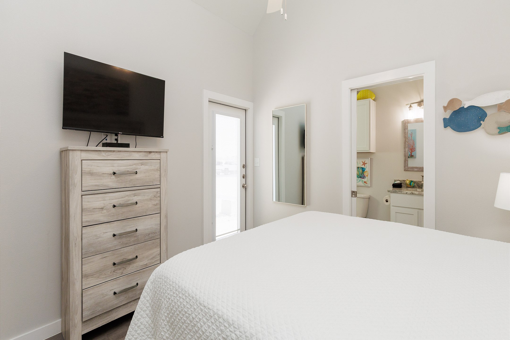 Master bedroom with king size bed, flat screen TV, and attached master bathroom 