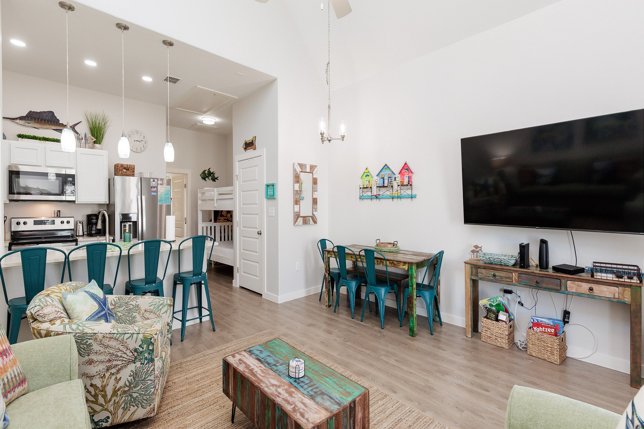 Cozy living space with arcade game, perfect for family fun, opening up to the kitchen and dining space