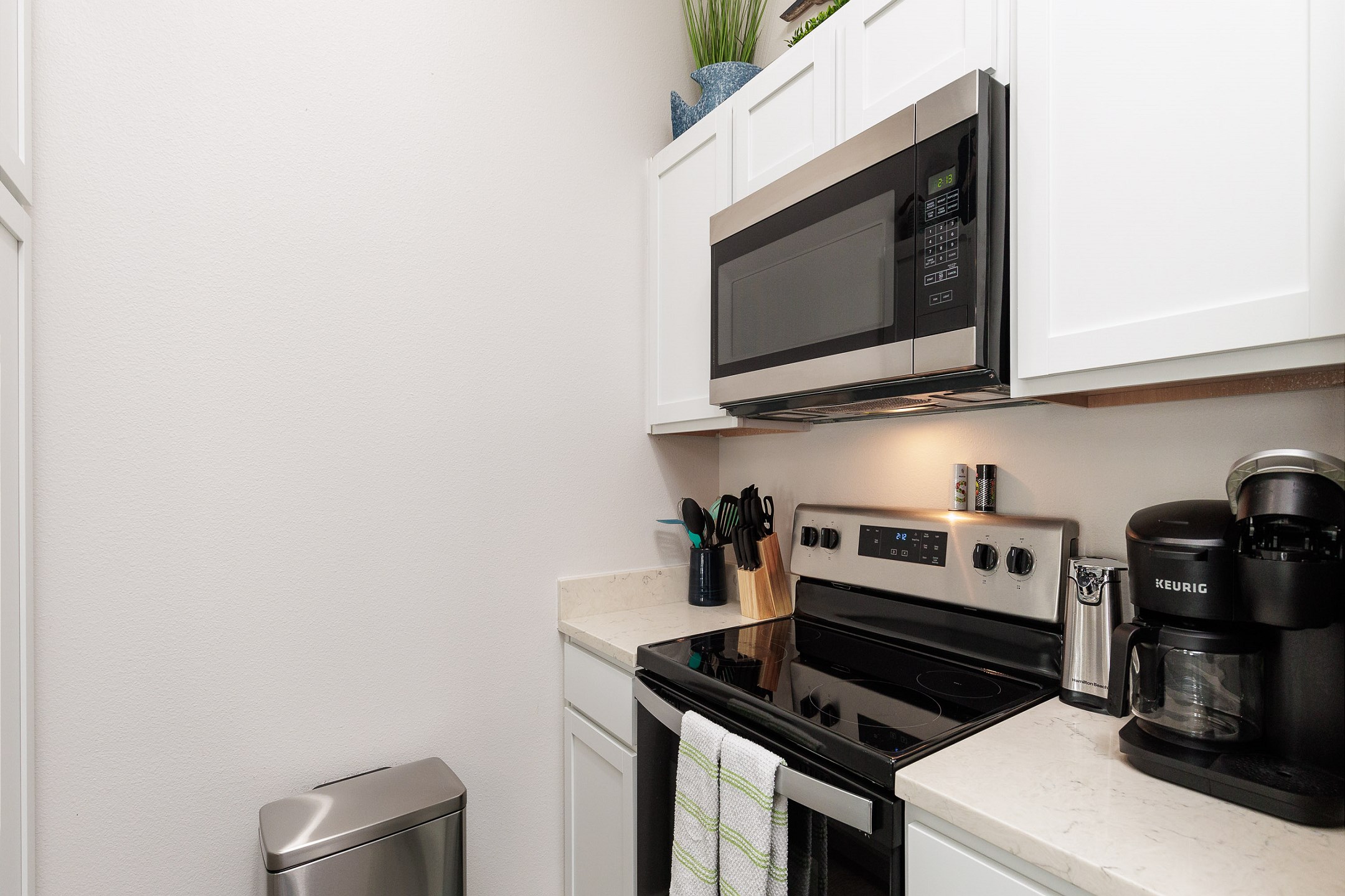 Fully equipped kitchen with stainless steel appliances including both full cup and Keurig coffee maker 