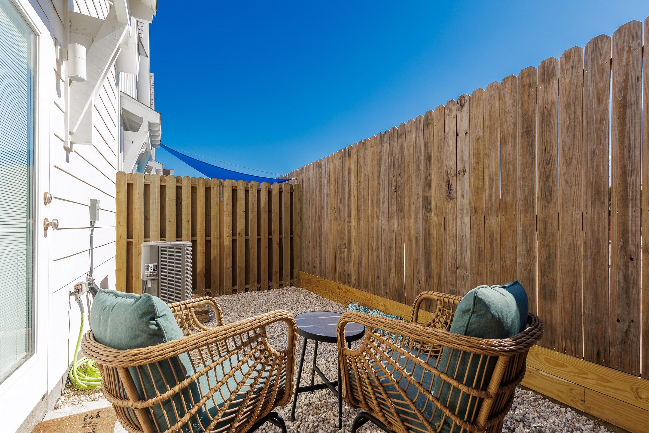 Unwind on the back patio, featuring cozy seating and a charming rockscape—perfect for relaxing under the open sky