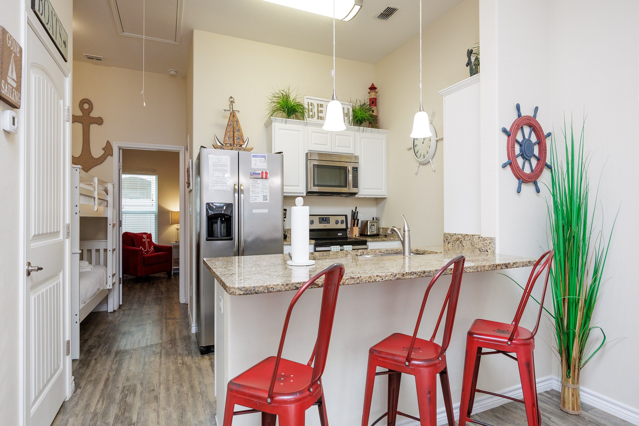 Fully equipped kitchen with stainless steel appliances and breakfast bar with seating for three