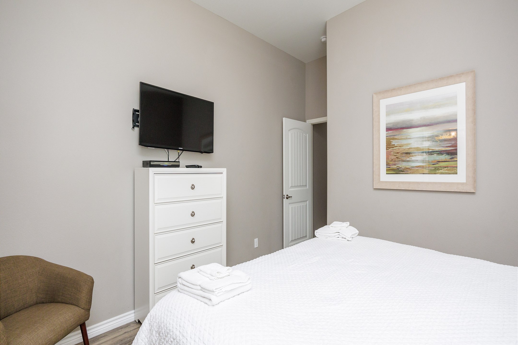 Master bedroom with a king size bed, private bathroom, and flat screen TV