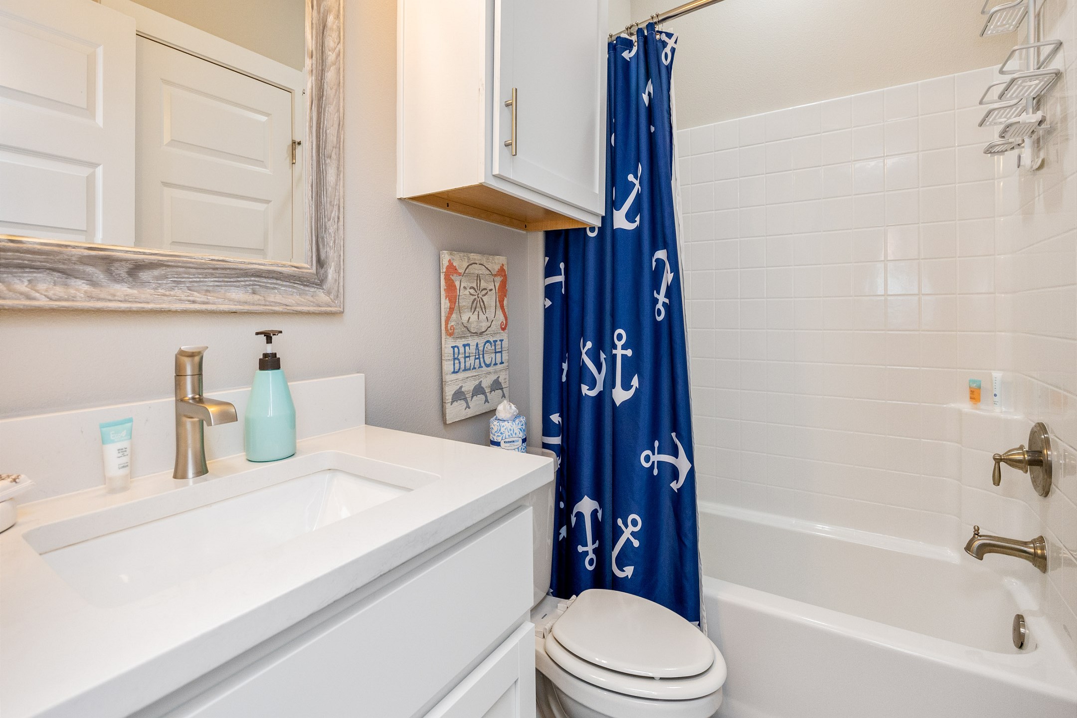 The guest bathroom on the second floor features a single sink and a convenient tub/shower combo—perfect for refreshing after a day of fun in the sun or winding down for a relaxing evening.