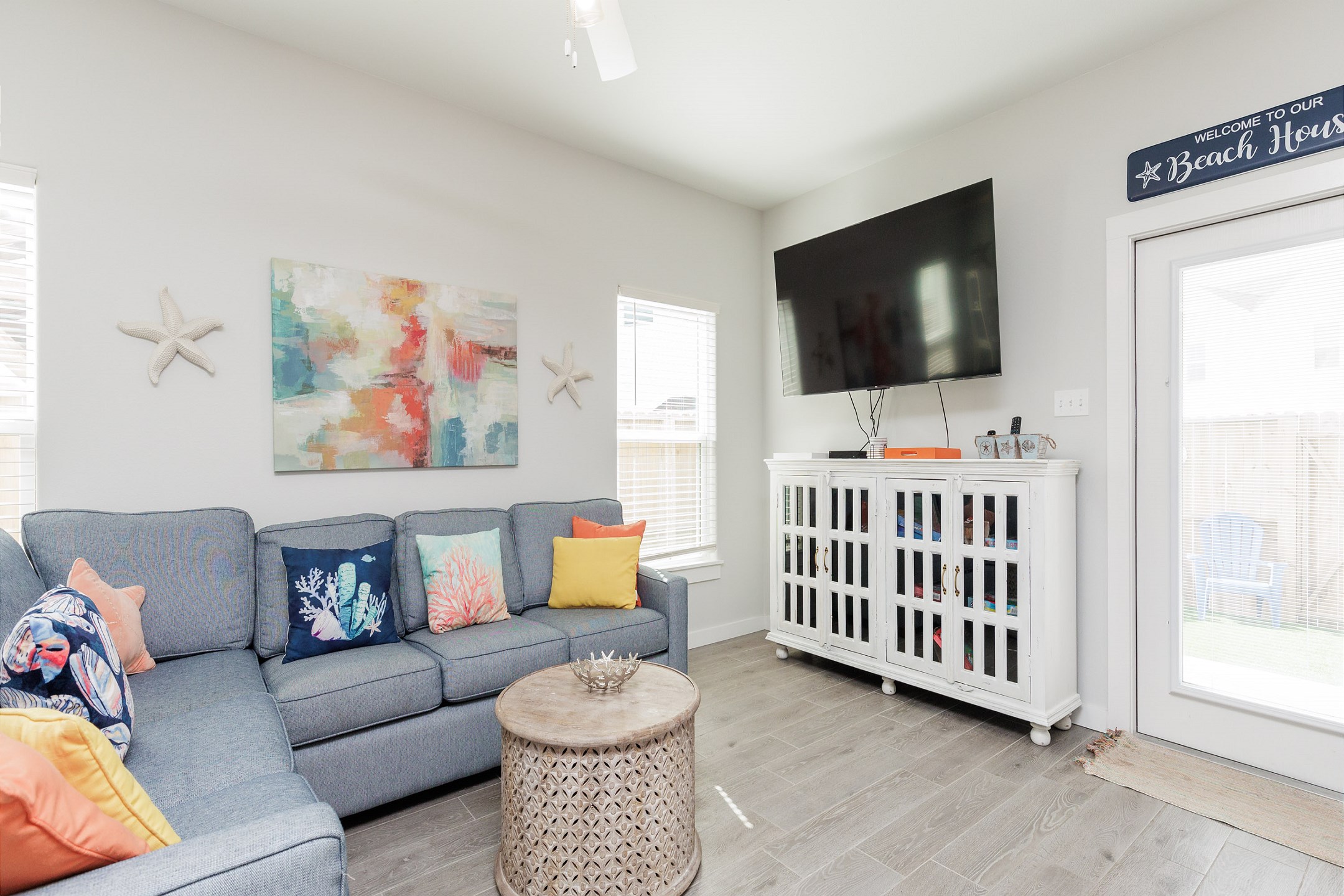 Living area with queen size sleeper sofa, flat screen TV and access to the patio space