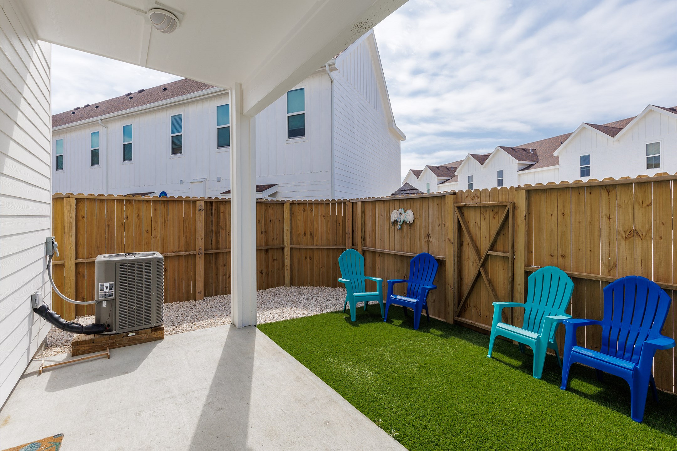 Private, fenced in patio with chairs and turf