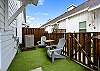 Back patio with comfortable seating and artificial turf grass