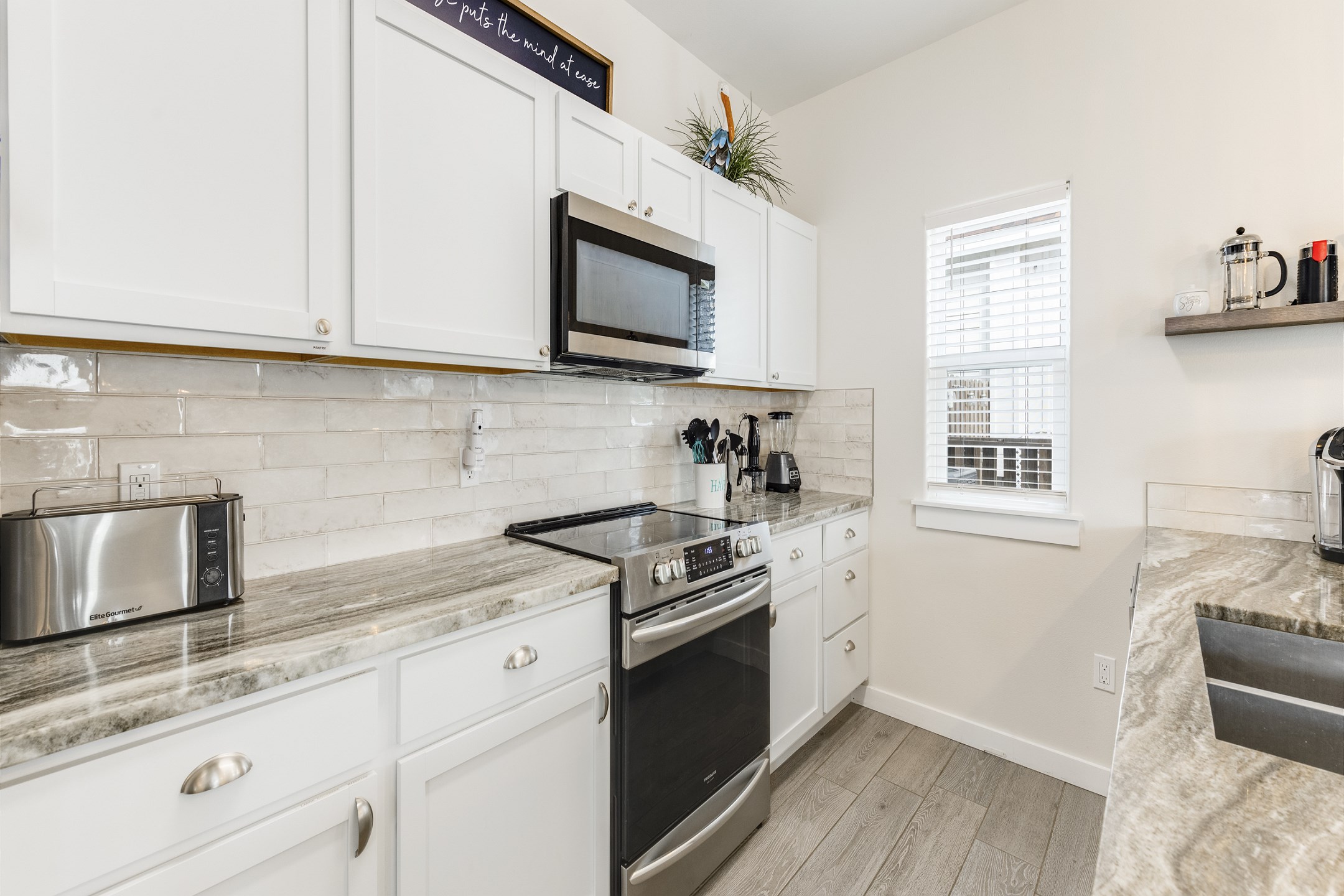 Fully equipped kitchen with coffee maker, toaster, cookware, dinnerware, and other kitchen essentials provided