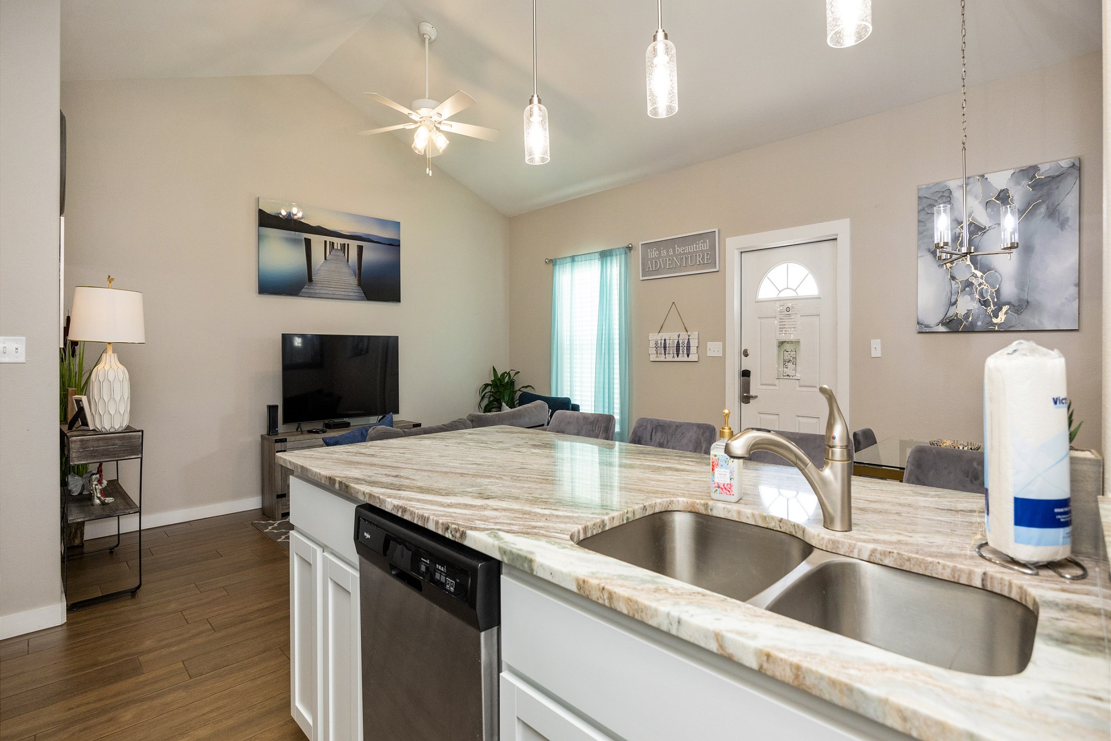 Bright kitchen area with beautiful modern light fixtures and plenty of counterspace 