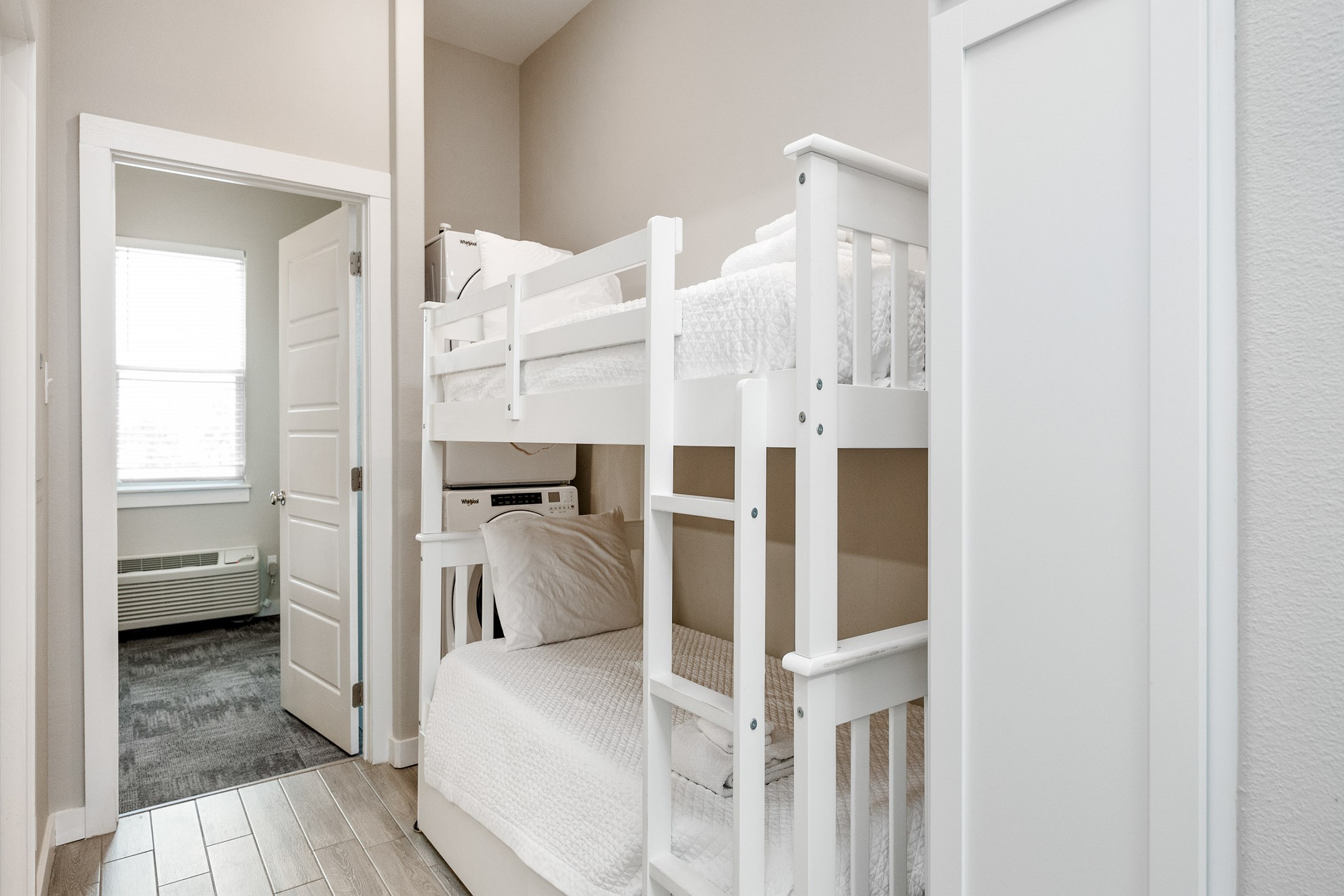 Twin size bunk beds and washer / dryer in hallway