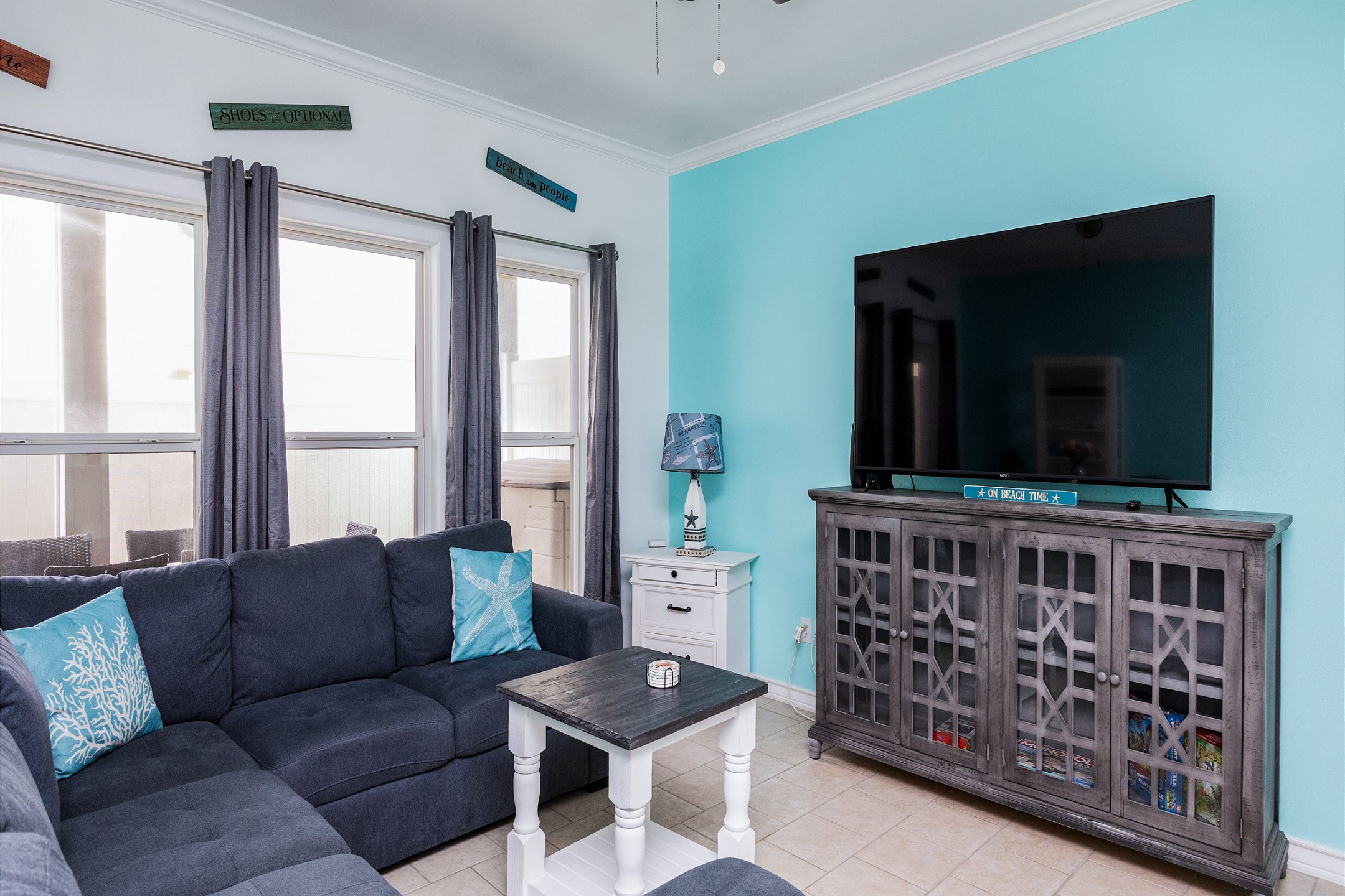 Open concept living area with modern furnishings like queen size sleeper sofa and flat screen TV 