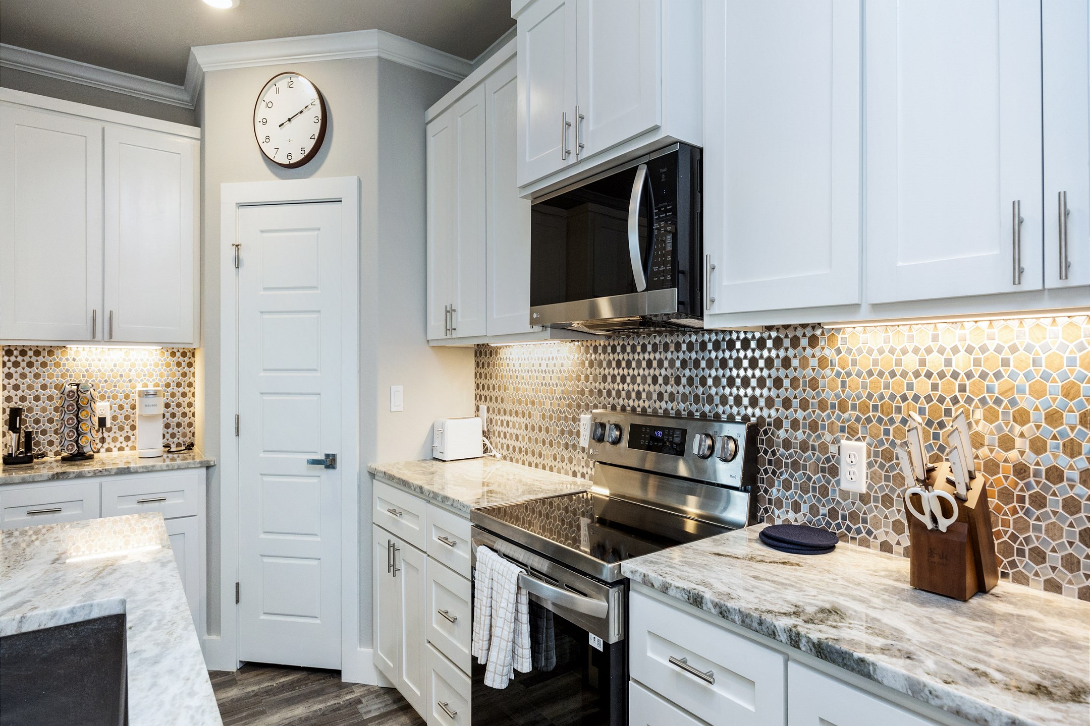 Sleek modern kitchen boasting granite countertops and ample space for preparing a full meal