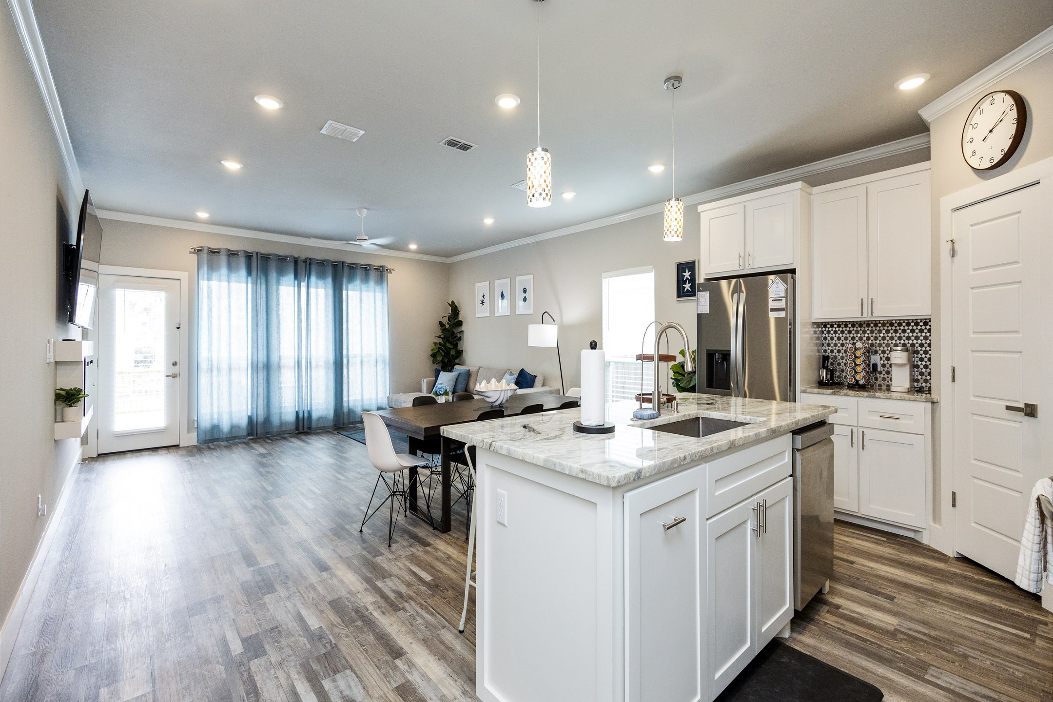 Stunning modern open floor plan with a cohesive flow between the living, kitchen, and dining areas