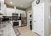 Modern kitchen with stainless steel appliances and washer/dryer in closet 